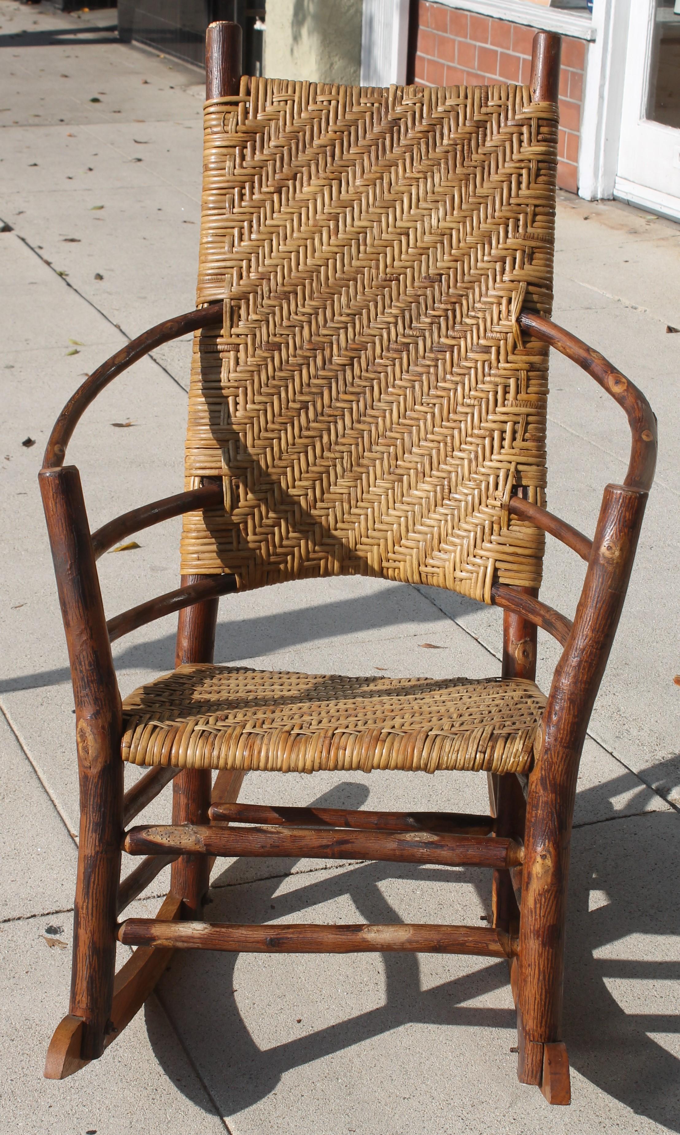 This amazing high back Old Hickory, Martinsville, Indiana & barrel back Old Hickory rocking chair. Primarily used on a covered porch or patio these rocking chairs are fantastic indoors as well. This rocker has the original hand woven split seat and