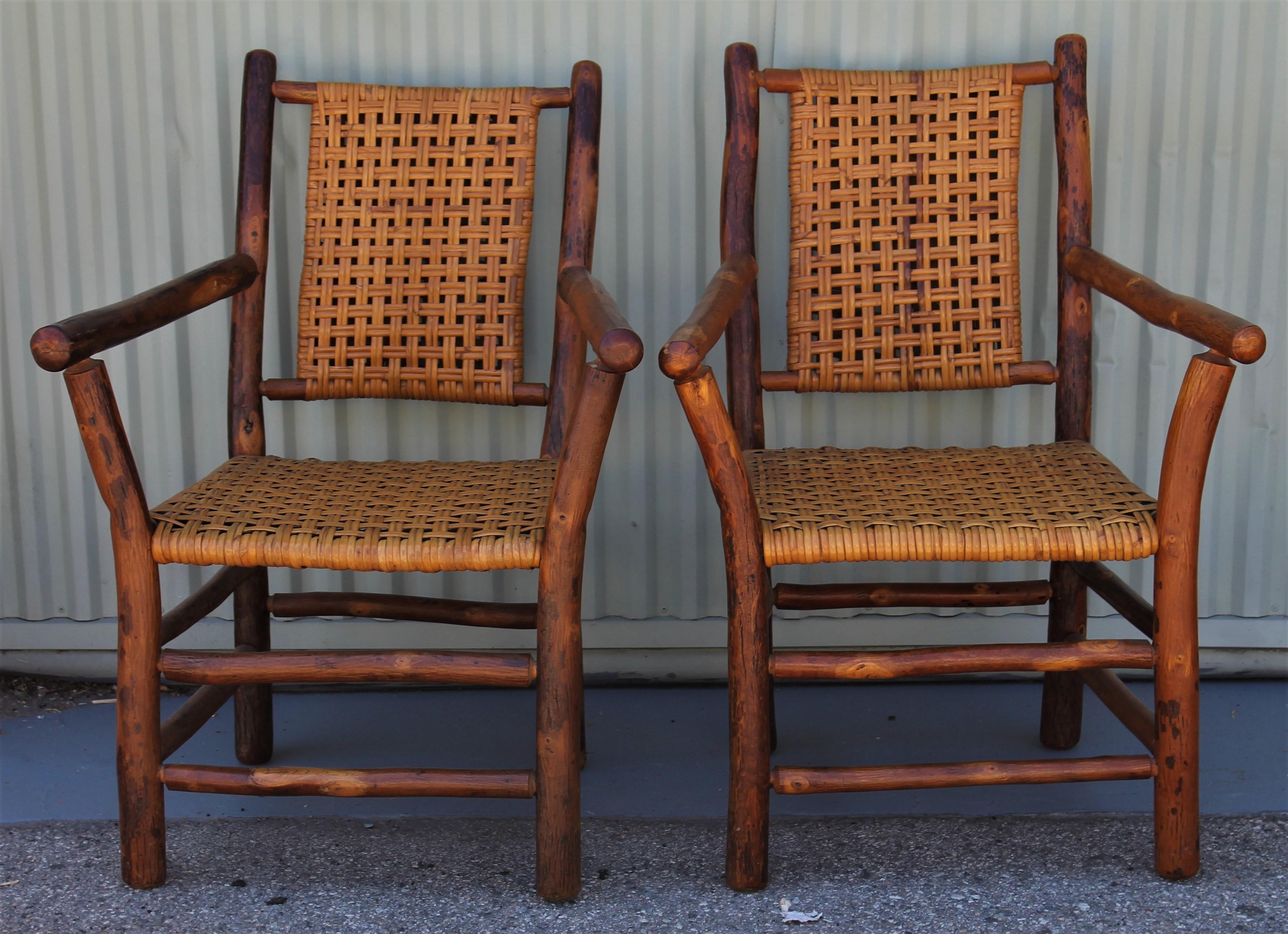 This pair of old hickory from Martinsville, Indiana side chairs are in pristine condition and have all original cane seats and backing. The chairs have the original old natural surface.