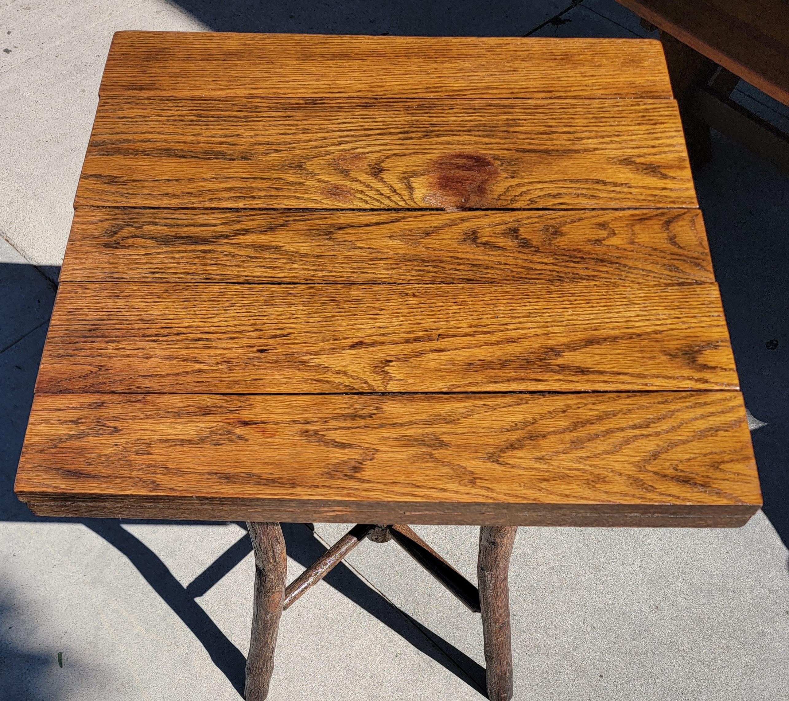 The lamp table has an oak top and flared hickory pole legs with spoke stretchers and an Old Hickory Bruce tag. Made by the Old Hickory Company in Martinsville, Indiana .The table is very strong and sturdy.