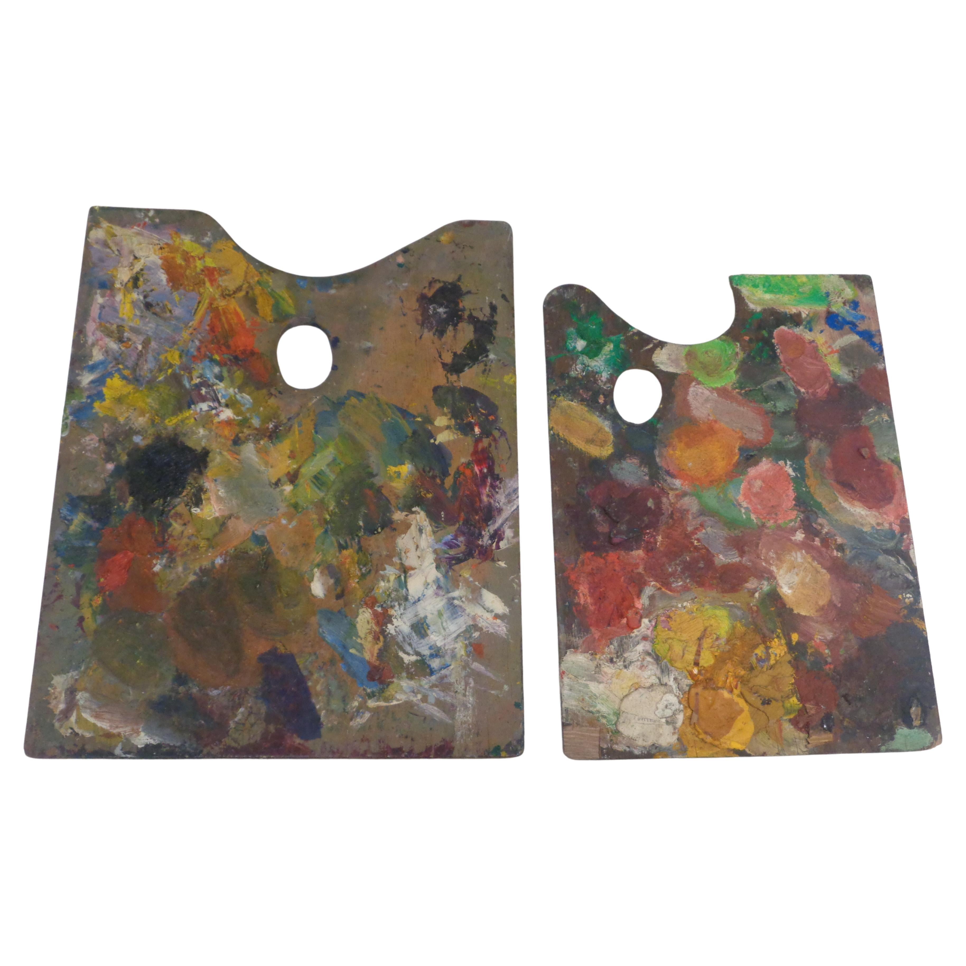 Zwei hölzerne Künstlerpaletten mit Impasto-Ölfarbe in schön gealterten Farben und dick verkrusteter Oberfläche. Jede Palette mit Farbe auf beiden Seiten. Um 1940er. Große Palette misst 15 1/2