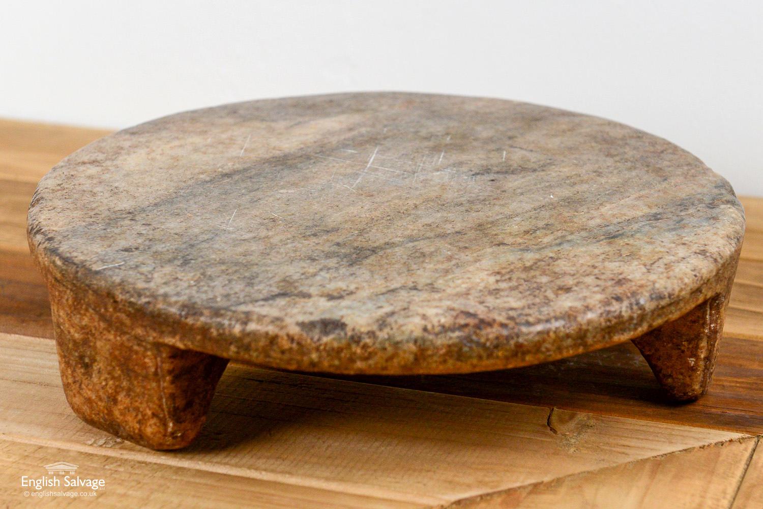 Simple hand carved stone chapati plate with signs of use which adds to its charm. One leg is chipped though it remains stabile and doesn't effect use.