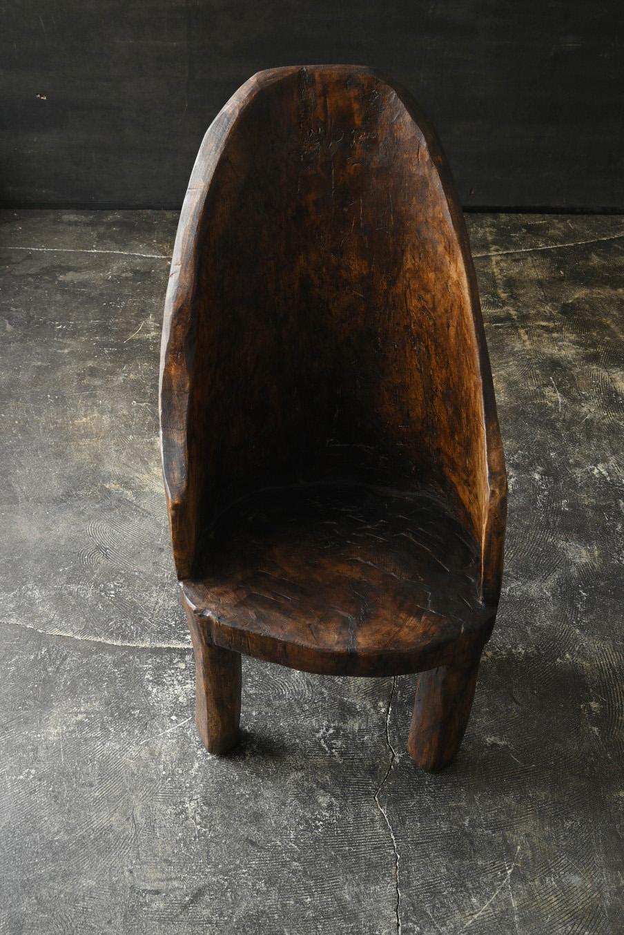This is an old wooden chair made in India, dating back to around the 20th century. Carved directly from a single log, it conveys a warmth and strength that can only come from handcrafted work—something that machine processing simply cannot
