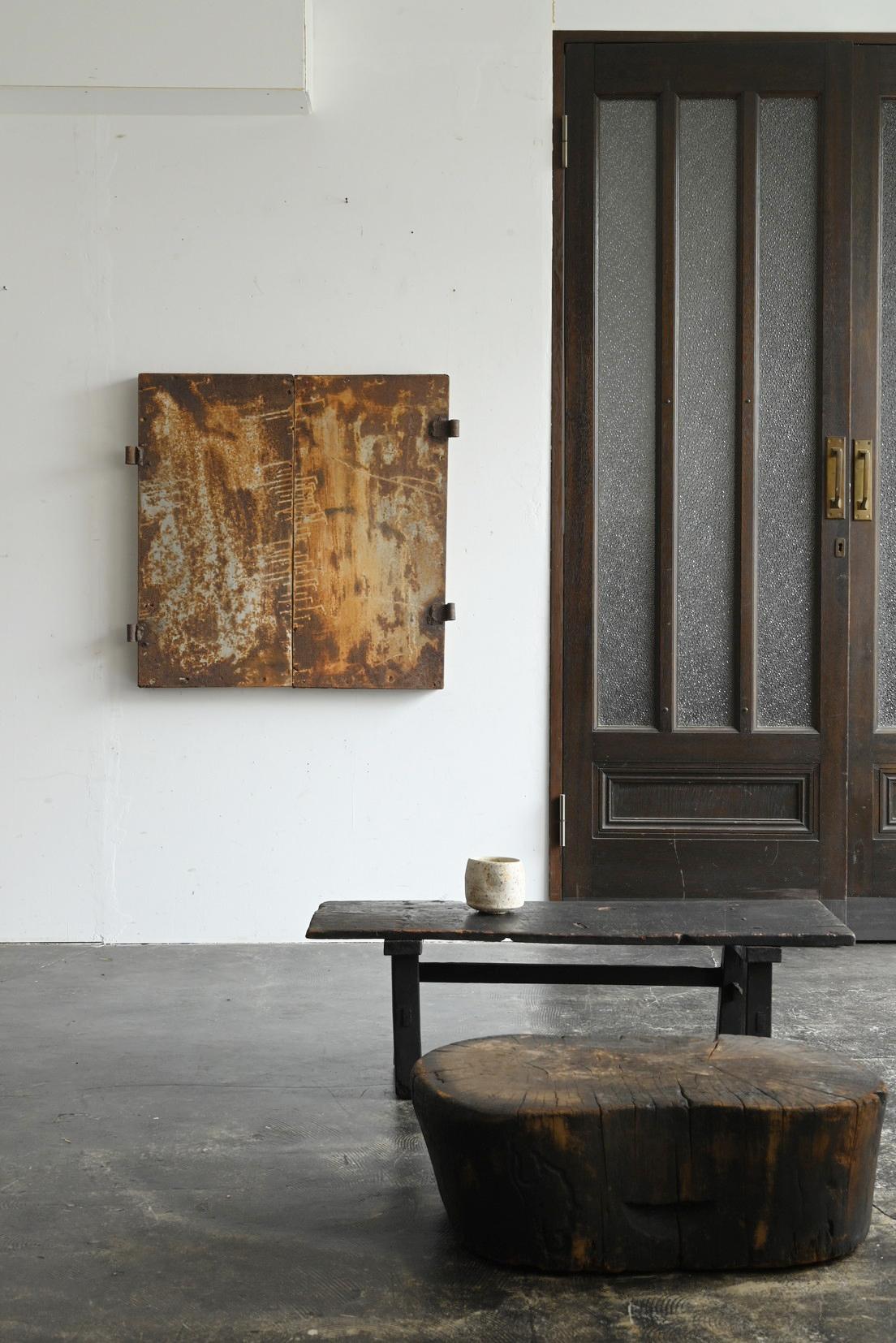This is a small, antique iron door from Japan's Showa period (circa 20th century). It was once installed in traditional Japanese homes and storehouses, and is believed to have served as a security measure by allowing small windows to be securely