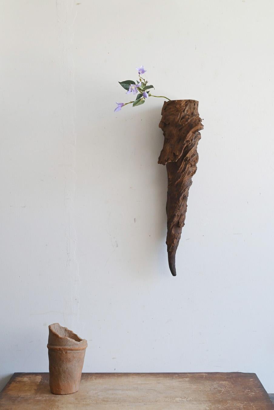 This is a vase made from the base of an old Japanese tree, thought to have been made around the 20th century. Although details of the wood are unknown, it is believed to be tsuga (Tsuga), a Japanese tree species. The unique shape formed by nature