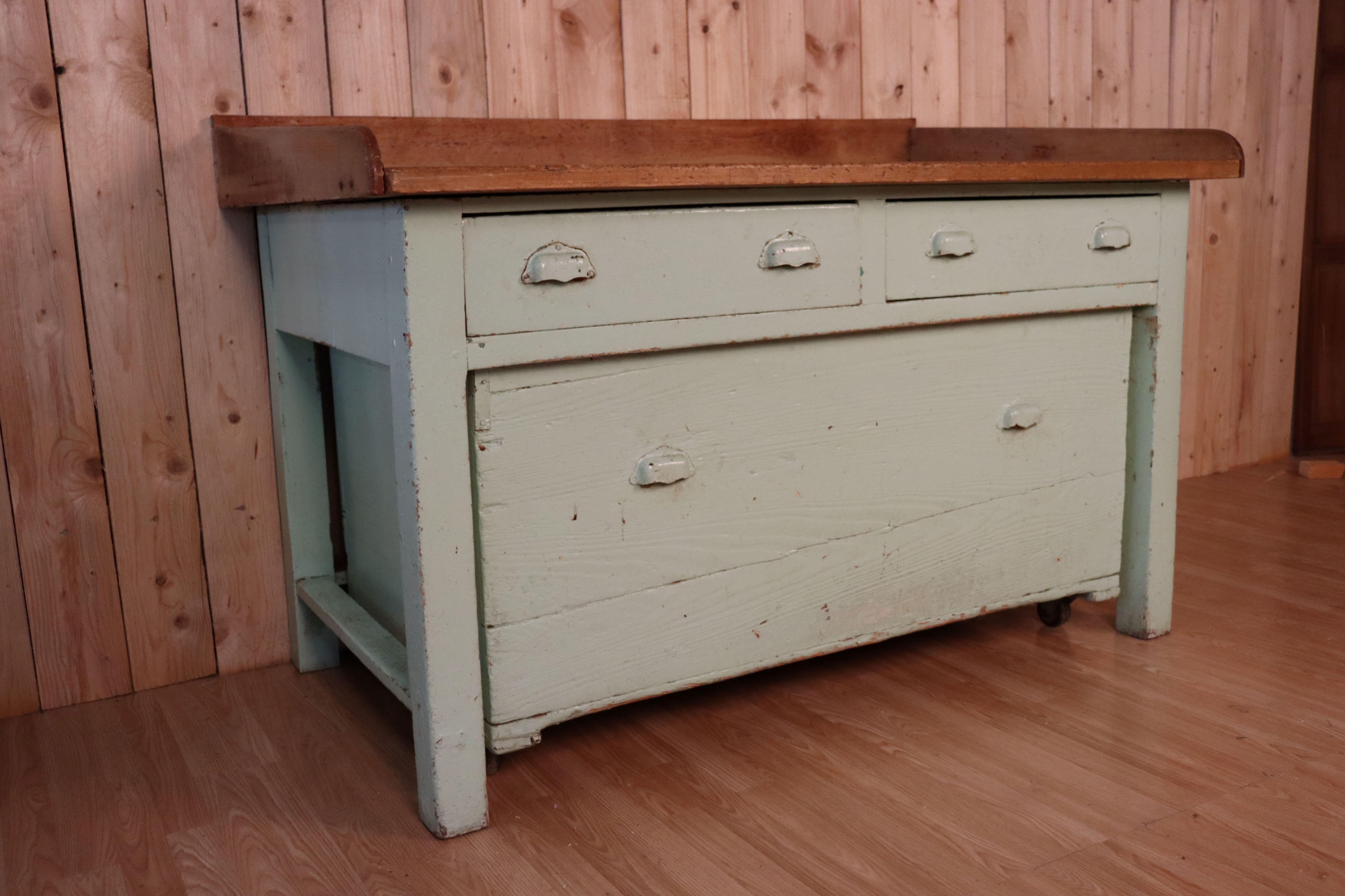 Old kitchen block from the 1950s, with its original patina (from a pastry laboratory) light green color furniture mounted on casters, two drawers and a box (also mounted on casters) below.