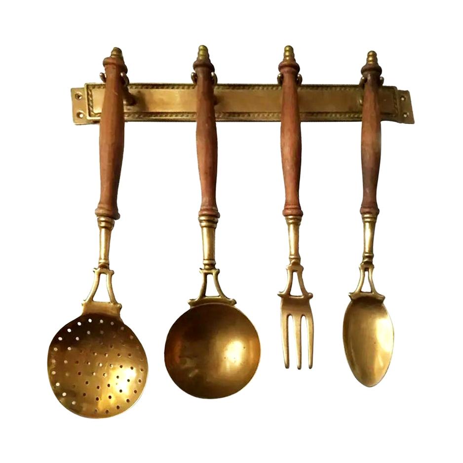 Old kitchen tools or utensils made of brass and wood hanging from a hanging bar. Old Kitchen Appliances,

Early 20th century

Saucepan fork palette and serving pot

This set of brass utensils is ideal to decorate a kitchen of any style, not