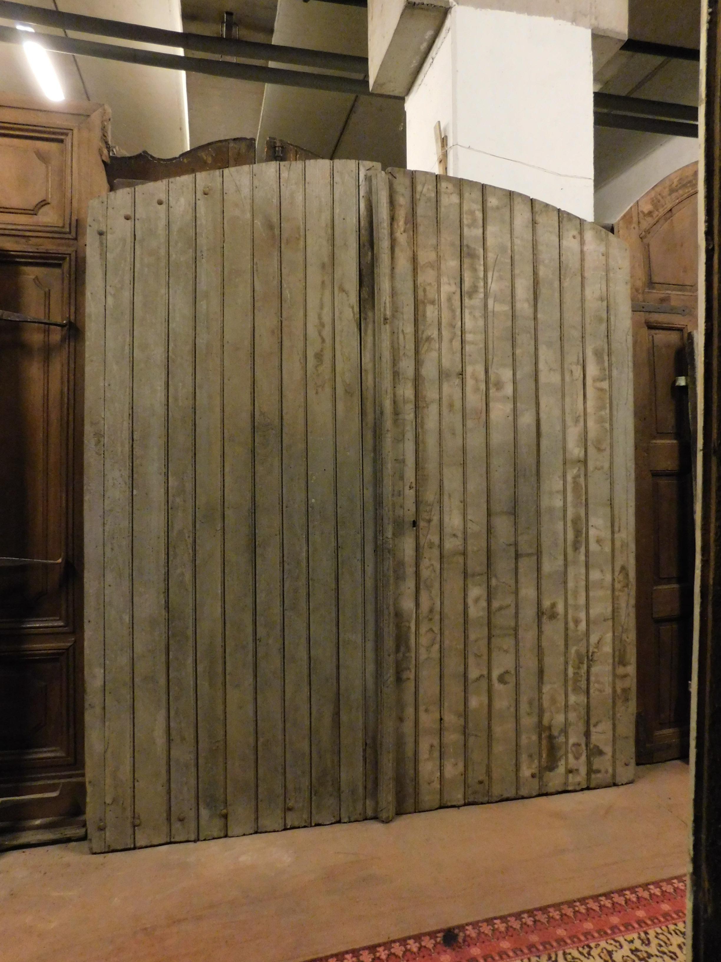 Ancienne porte d'entrée, porte principale, fabriquée à la main en bois mixte, de forme nervurée, patinée par le temps, construite à la fin du XIXe siècle pour une ferme rustique du nord de l'Italie (Piémont). Le dos est également fini et les