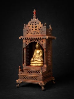 Old metal temple with antique wooden Buddha statue from Nepal