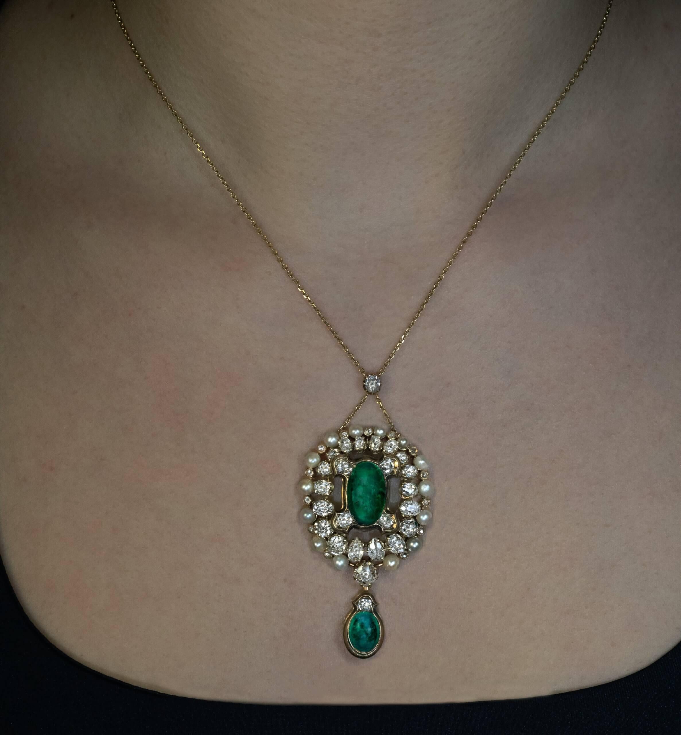 hacia 1850
Este collar antiguo de oro de 18 quilates tiene dos esmeraldas colombianas antiguas talladas en cabujón, acentuadas por perlas y gruesos diamantes antiguos tallados de varias formas y tamaños. Las esmeraldas tienen un excelente color