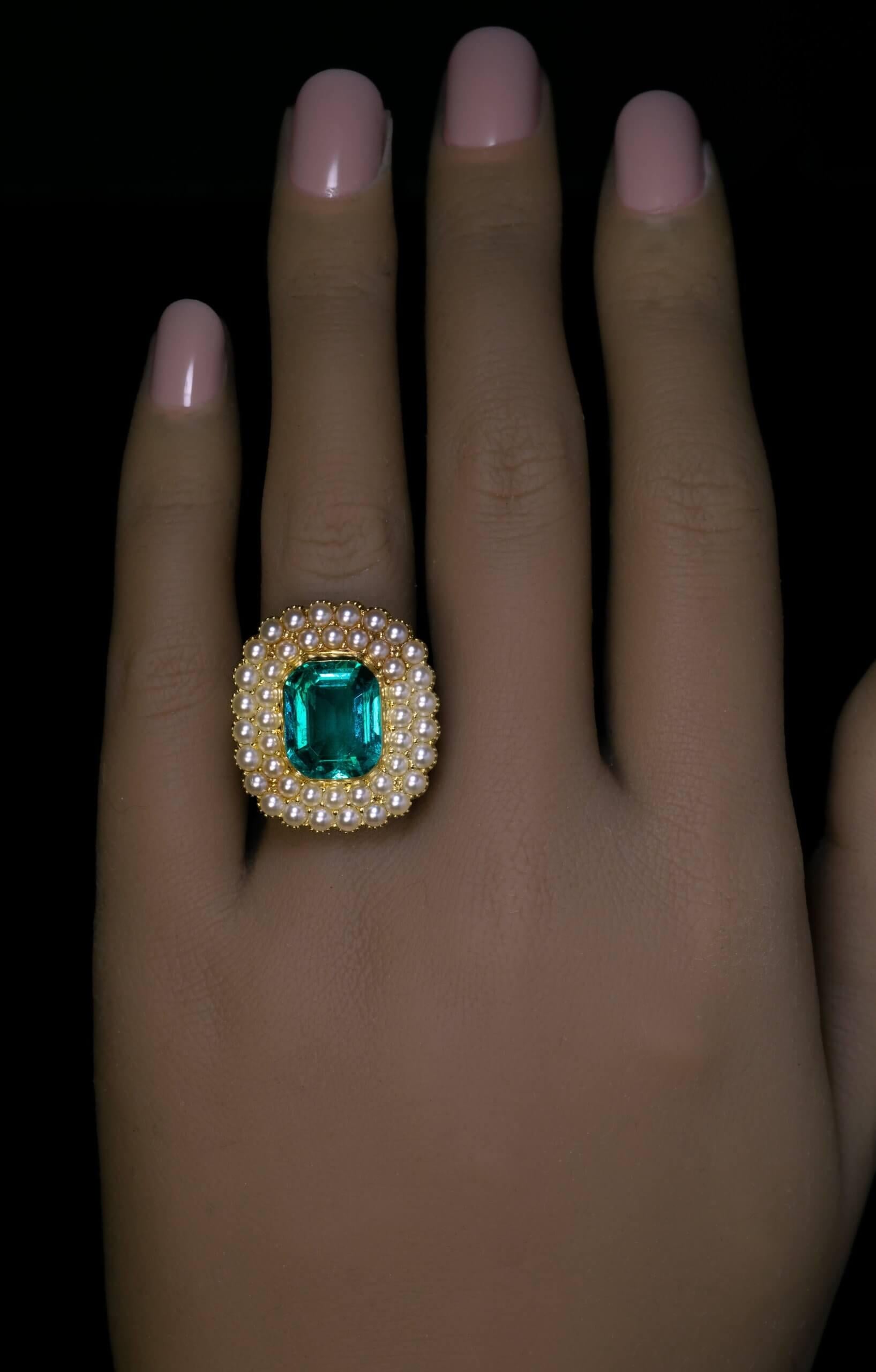 CIRCA 1850  Dieser antike Goldring zeigt einen prächtigen kolumbianischen Smaragd aus alter Mine, der von zwei Reihen Saatperlen eingerahmt wird. Der Smaragd hat eine lebhafte bläulich-grüne Farbe und funkelt ausgezeichnet.  Der Smaragd ist etwa