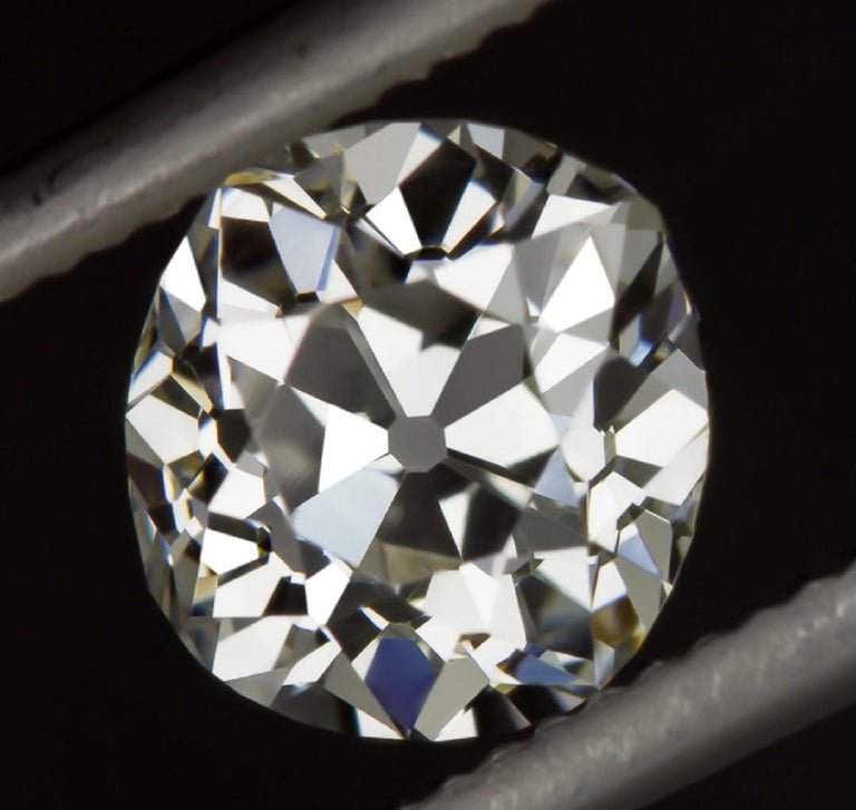 This striking and bright white 0.97ct old mine cushion cut diamond has charmingly wide hand cut facets that sparkle dazzlingly and have spectacularly vivid fire! Graded F for color, it is brilliantly white, a rare feature in old cut diamonds! Cut by