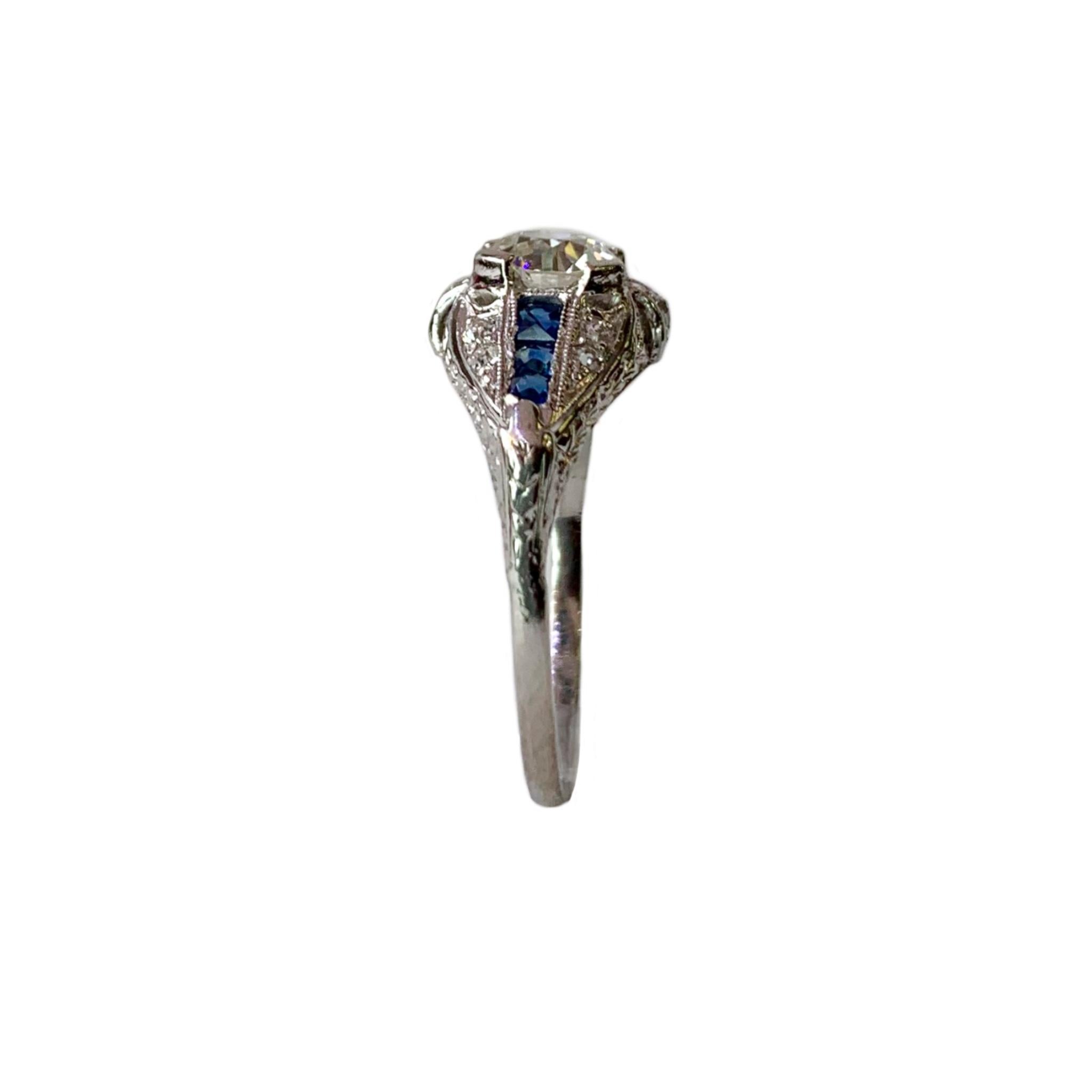 Stunning Art Deco platinum ring with 1.02ct old mine cut diamond, SI1 clarity, J-K color and twelve old European cut diamonds total weight approximately .15cts, and six square French cut blue sapphires.
