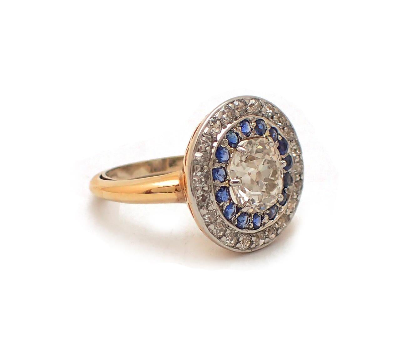 Explore history with this gorgeous Old Mine cut diamond ring featuring a 2.33ct center diamond, J-K Color, SI clarity. The center stone is surrounded by a double halo containing one circle of vivid blue sapphires, and one with white round single-cut