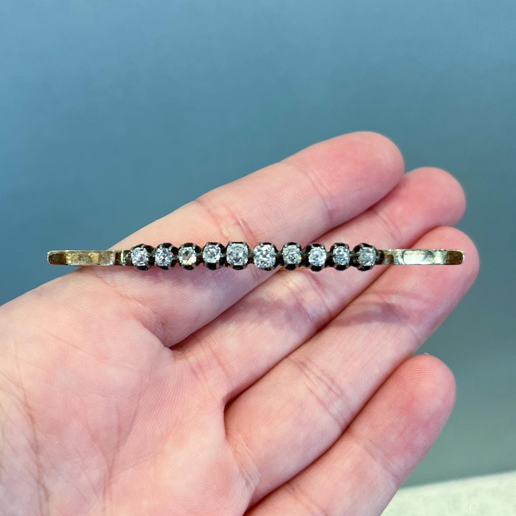 This is a perfect gift for your vintage jewelry lover! Nearly 150 years old and still fabulous, this gorgeous diamond bar brooch is beautifully made in 14 karat yellow gold and sterling silver! Made around 1875, ten old mine cut diamonds sit in