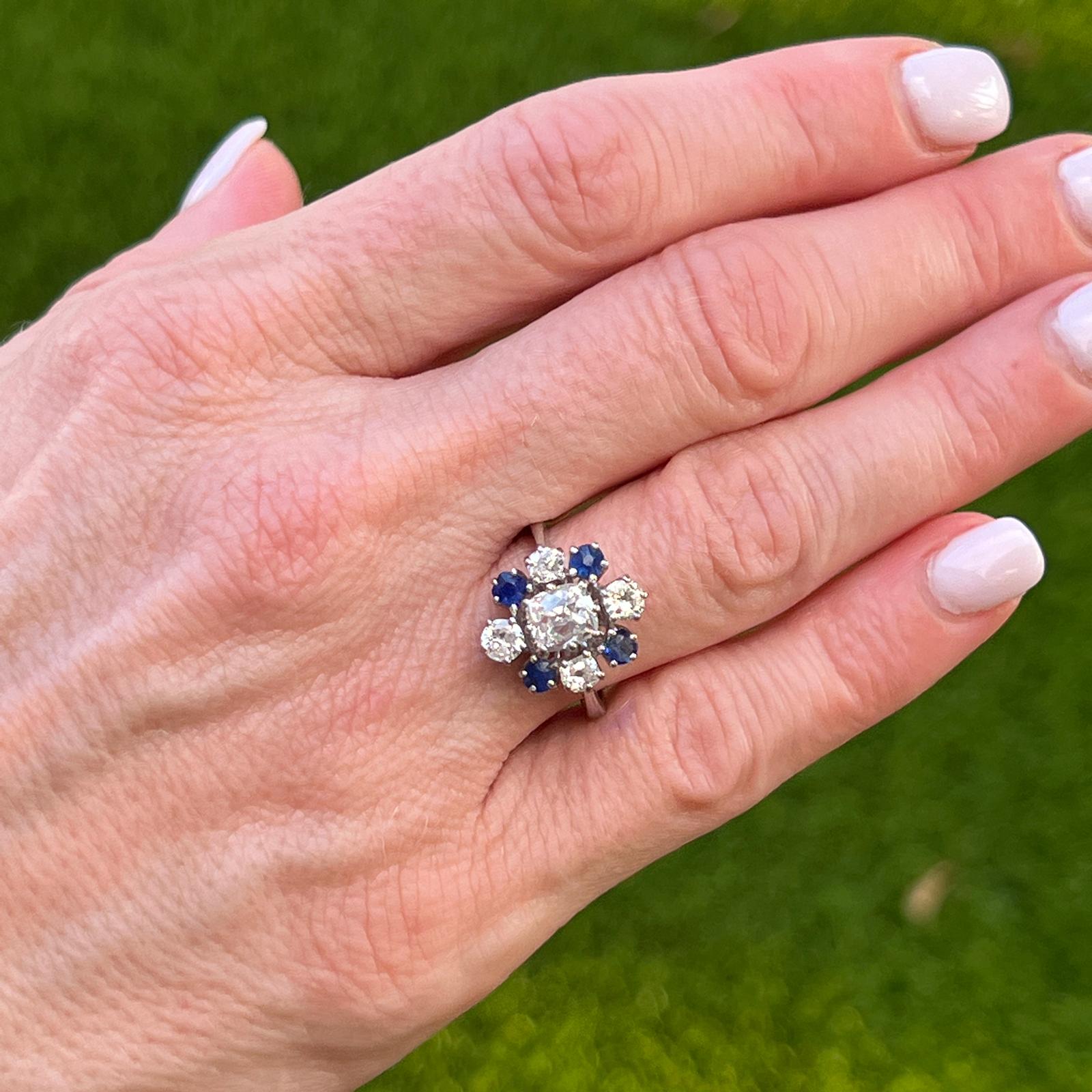 Beautiful diamond and sapphire ring circa early 1900's. The ring features an Old Mine Cut center diamond weighing 1.02 carats (exact weight). Another 4 Old Mine Cut diamonds weigh approximately .60 CTW. The 4 natural blue sapphires weigh