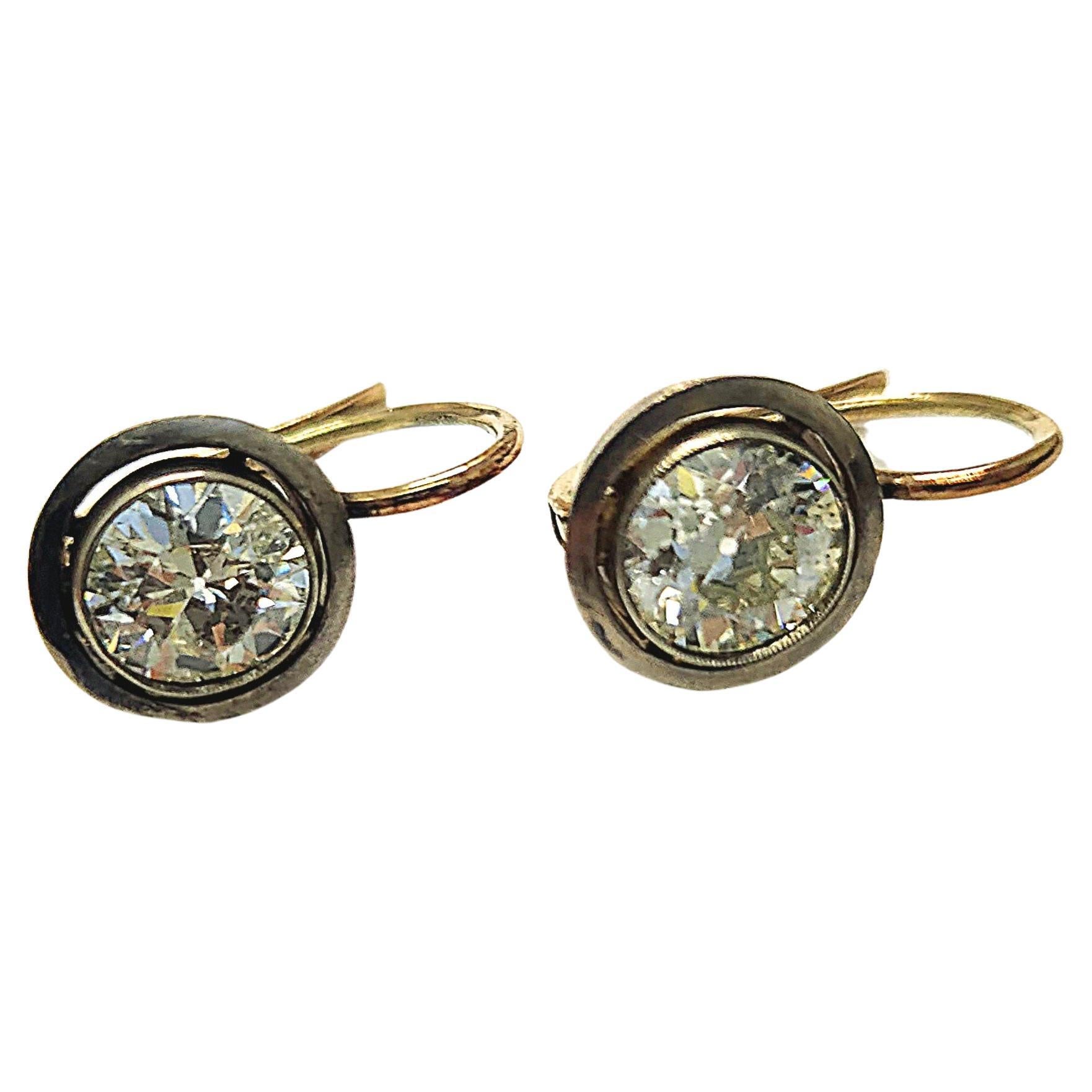 14k gold earrings in solitaire style with 2 old mine cut diamonds total weight of 2 carats 6.1mm diameter each stone H color white vs clearity excellent cut and spark