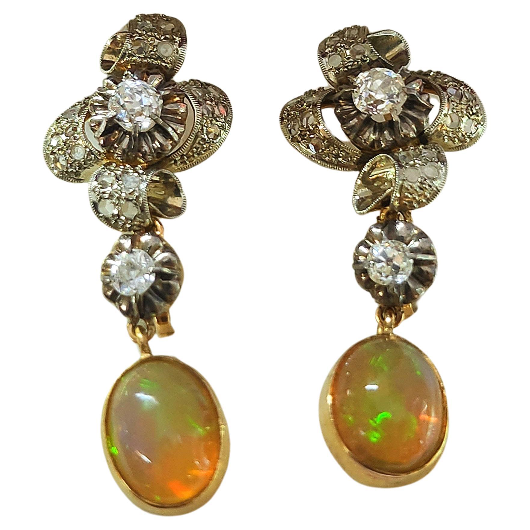 Antique earrings in 18k 2 tone colors gold with an estimate old mine cut diamond weight of 0.90 carats H color vs clearity dangling with natural australian fire opal in oval cut earrings hall marked on the back