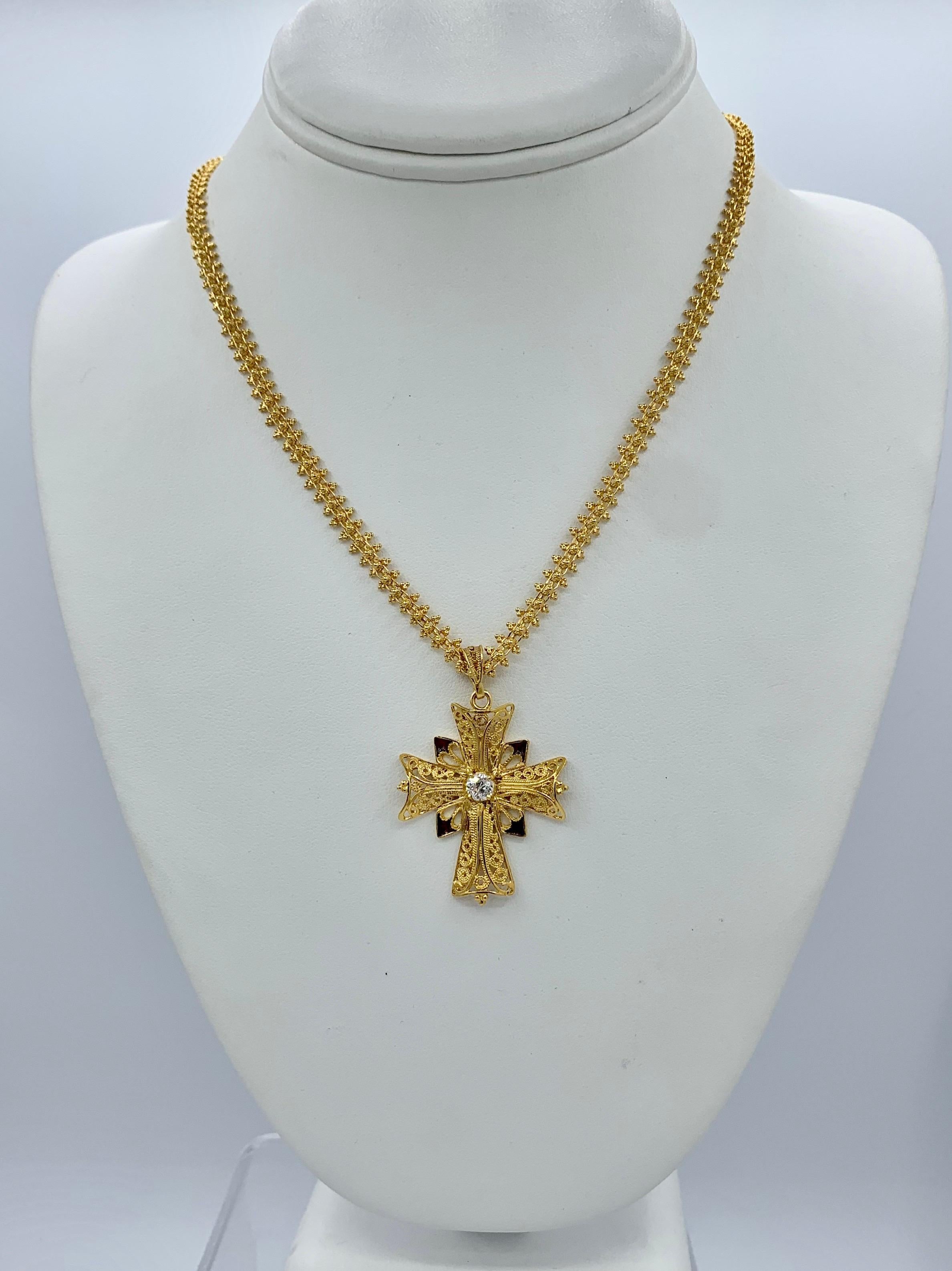 This is a magnificent antique Cross Pendant Necklace set with a Cross with a sparkling Old Mine Cut Diamond and Red Enamel hanging from an ornate 18 Karat Gold Chain with a gorgeous Green Tourmaline Clasp.  The cross is a beautiful filigree design. 