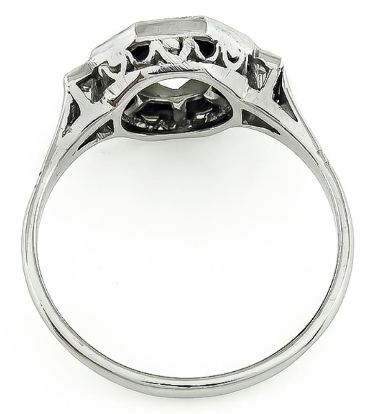 This fabulous platinum engagement ring from the Art Deco era is centered with a sparkling old mine cut diamond that weighs approximately 0.80ct. graded J color with SI1 clarity. The diamond is accentuated by dazzling baguette cut diamond and onyx