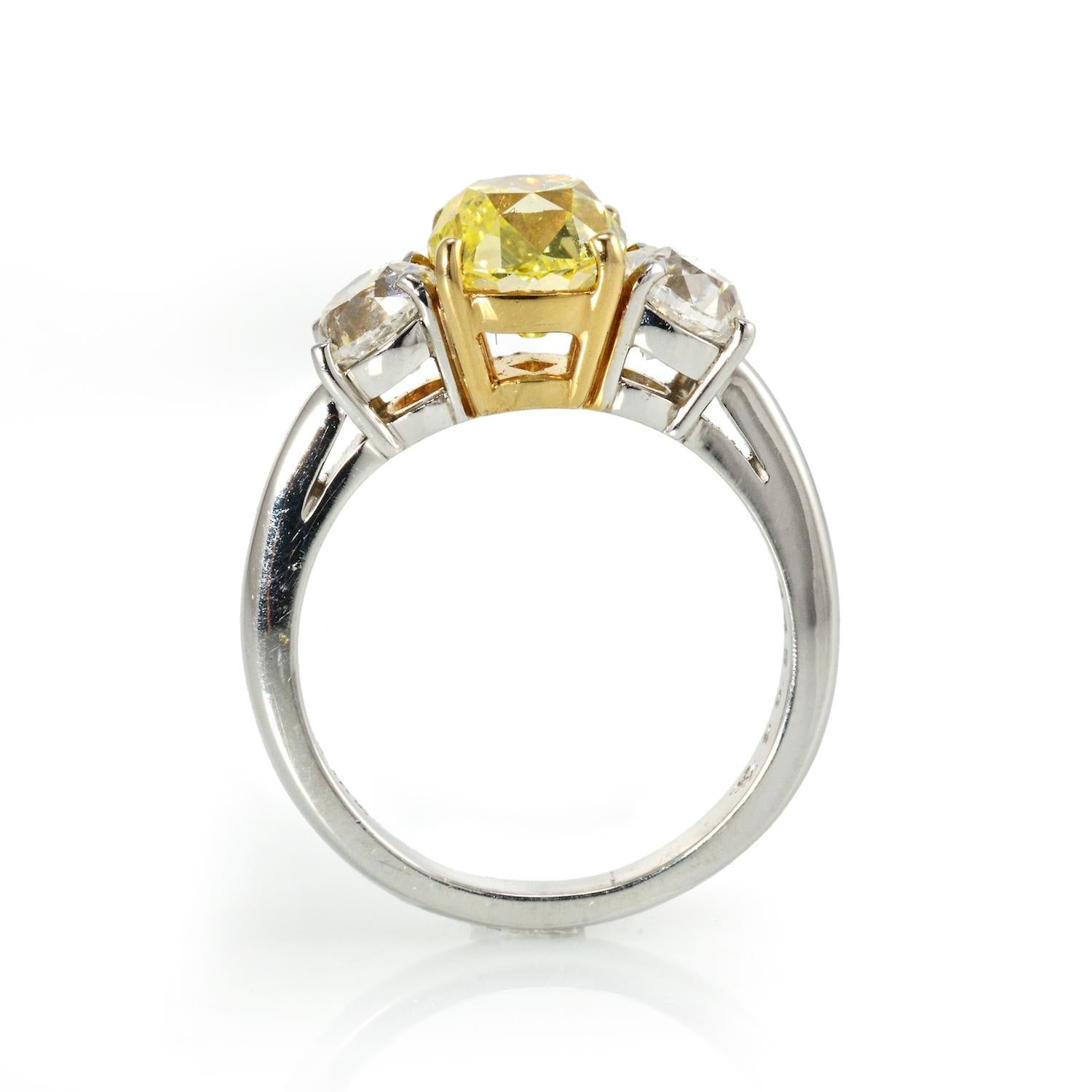 2.02 carat Fancy Yellow Old Mine Diamond Old Mine Brilliant Intense Fancy Green-Yellow Three Stone Ring

Three-stone diamond ring, centering on an old-mine brilliant-cut fancy intense green-yellow diamond weighing 2.02 carats, flanked by two