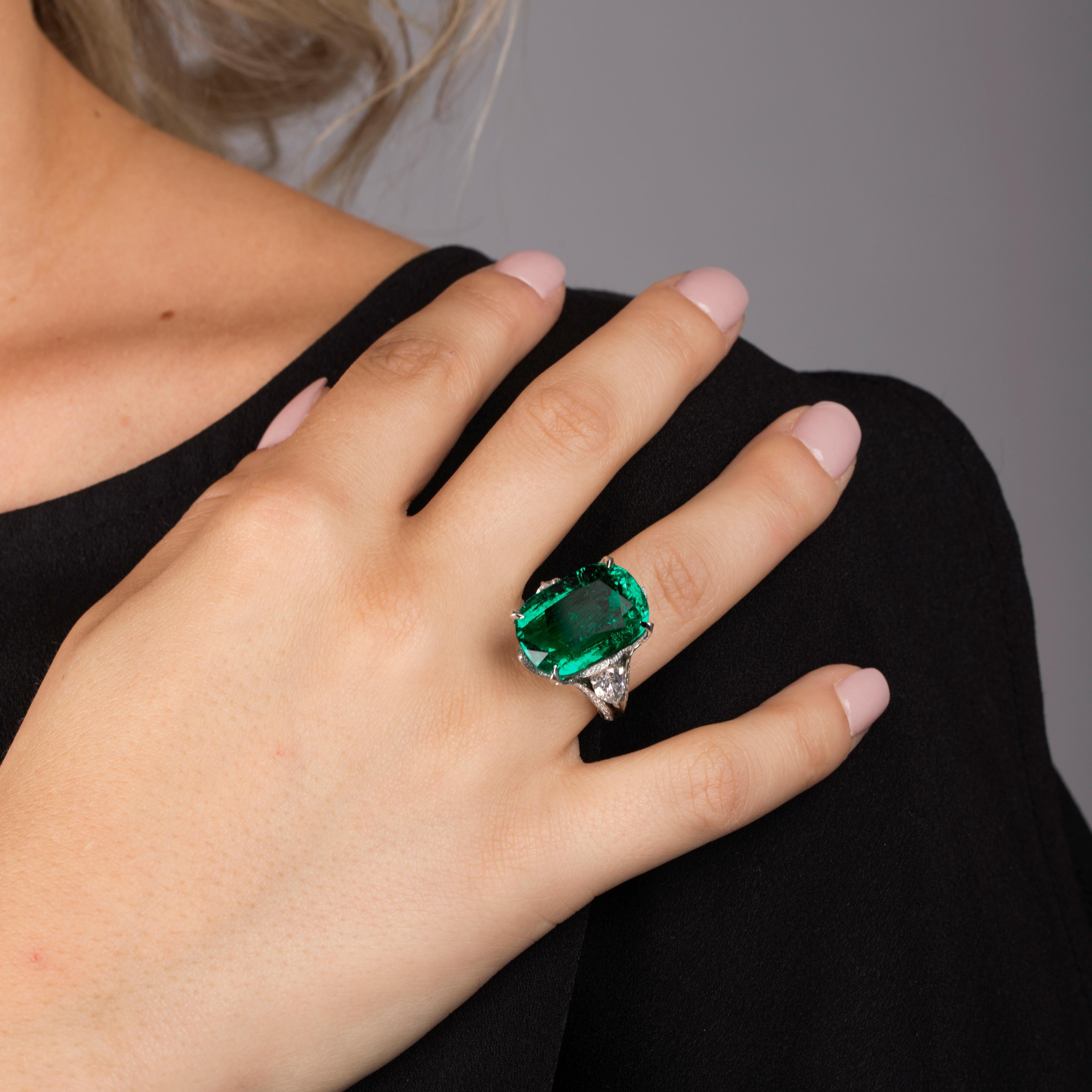 This emerald is 18.43 carat and has been mined in Colombia.
The emerald is intense green with good clarity and is an old mine emerald.
This is a cushion cut emerald and surrounded by diamonds in a unique setting.
Features pear shaped diamonds on