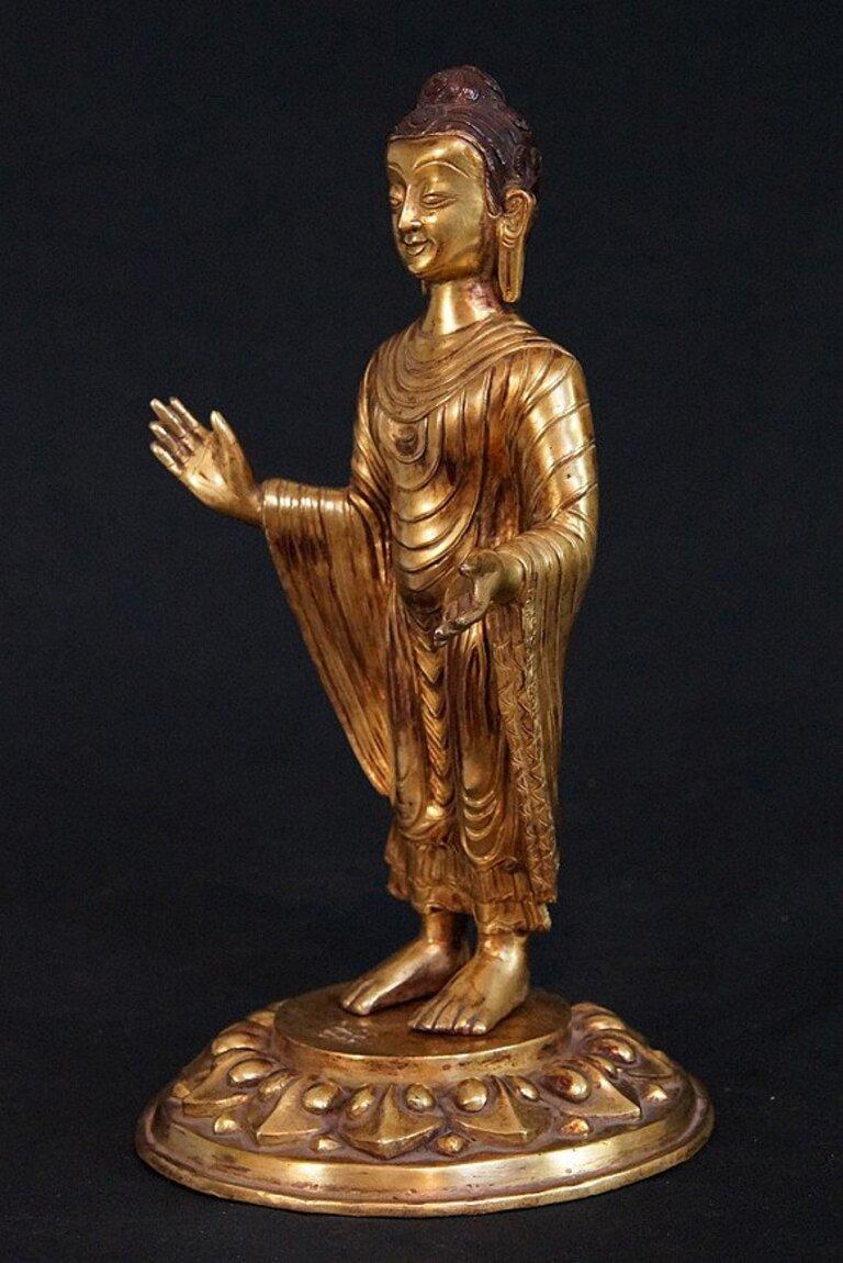This antique bronze Buddha statue is a truly unique and special collectible piece. Standing at 31 cm high and 17.5 cm diameter, it is made of bronze and it is fire gilded with 24 krt gold. This statue is believed to originate from Nepal and dates