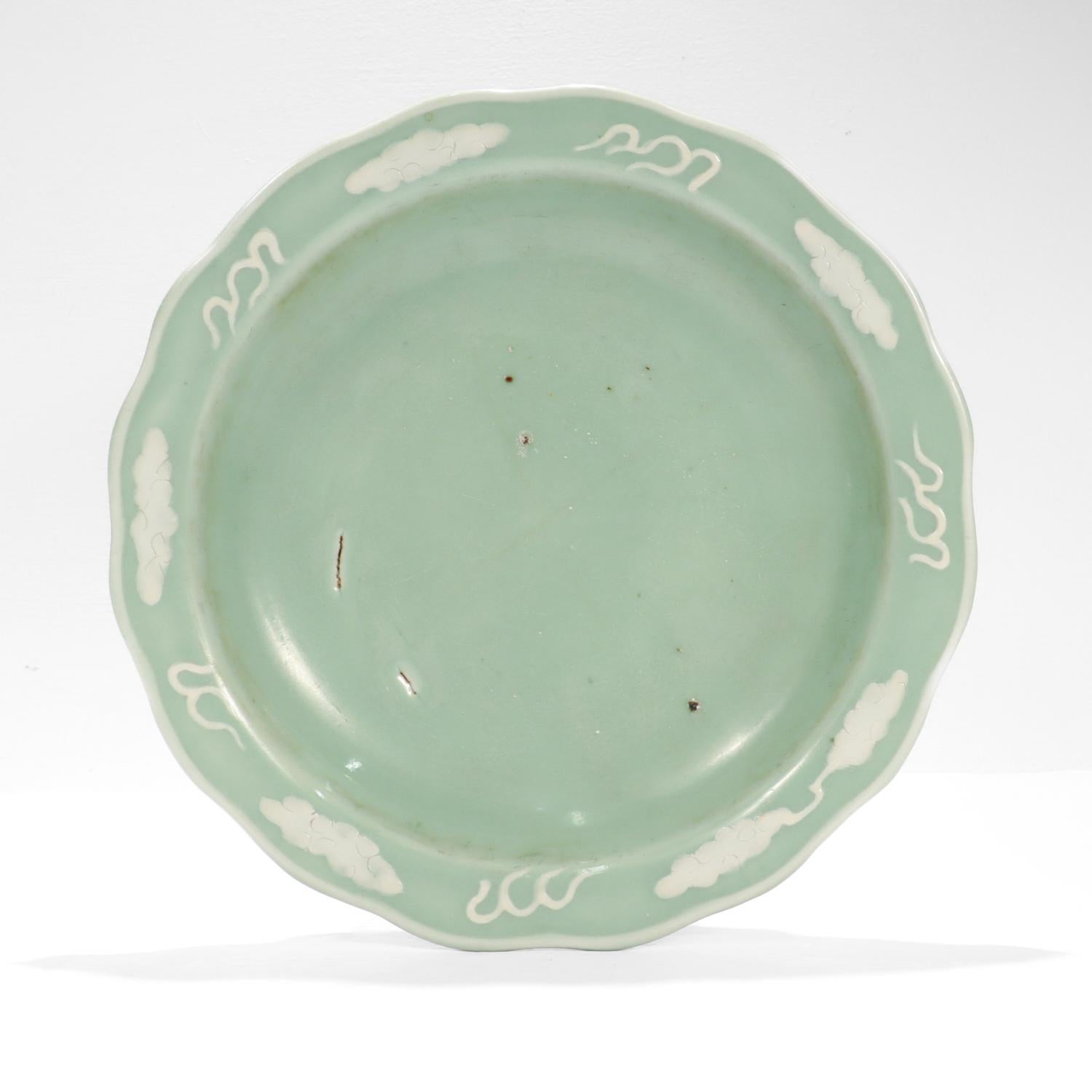 Fino cuenco antiguo de porcelana china de celadón.

Con acentos y reflejos blancos sobre un cuerpo verde celadón pálido. 

El cuenco tiene el borde ligeramente festoneado con un reborde blanco.

Toda la pieza está decorada con representaciones