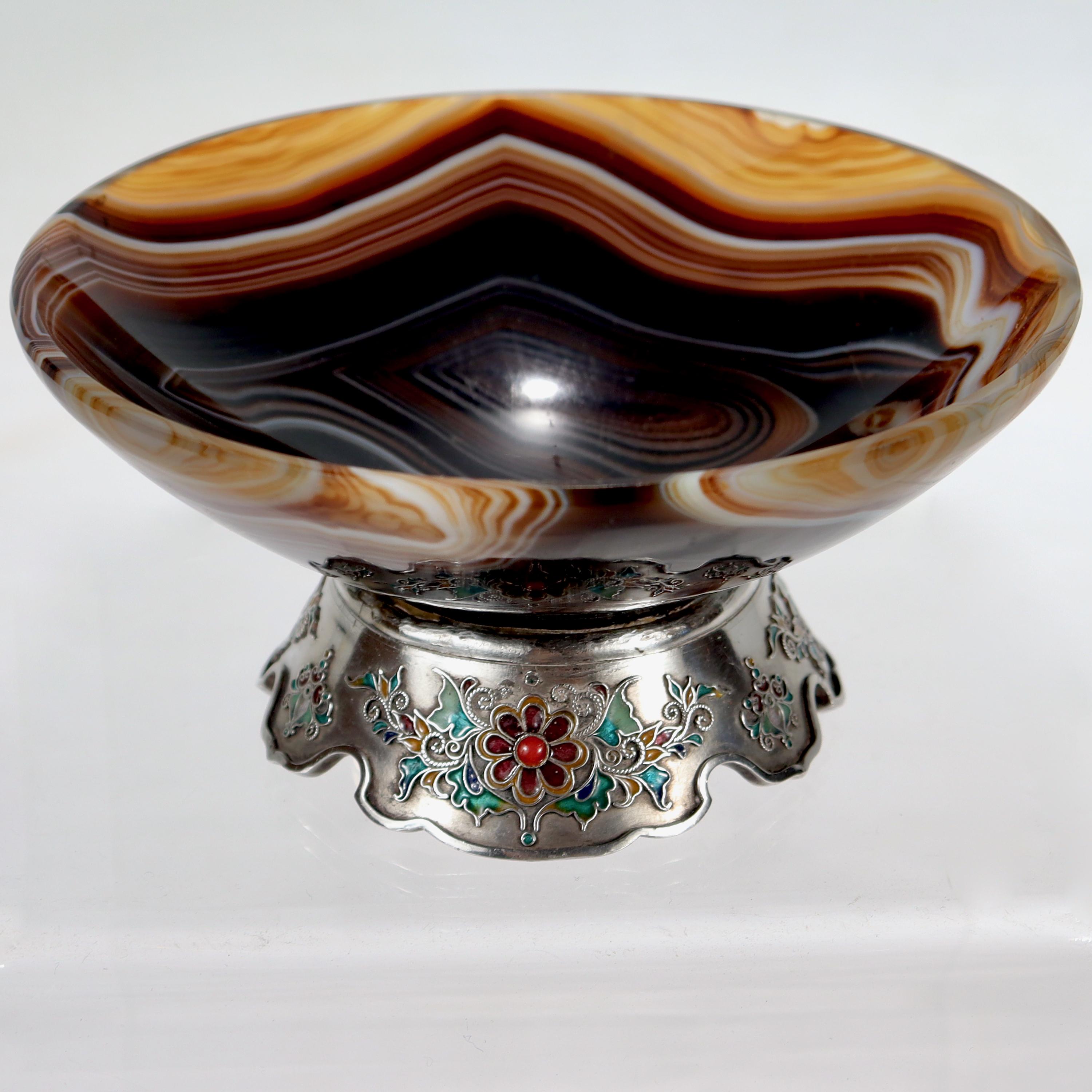 A fine silver, enamel, & agate bowl.

With a carved agate bowl mounted on a silver & enamel base.

We're unsure about the bowl's origin, although we have a strong inclination to think that it's Austrian.

The base has intricate embossed flowers in