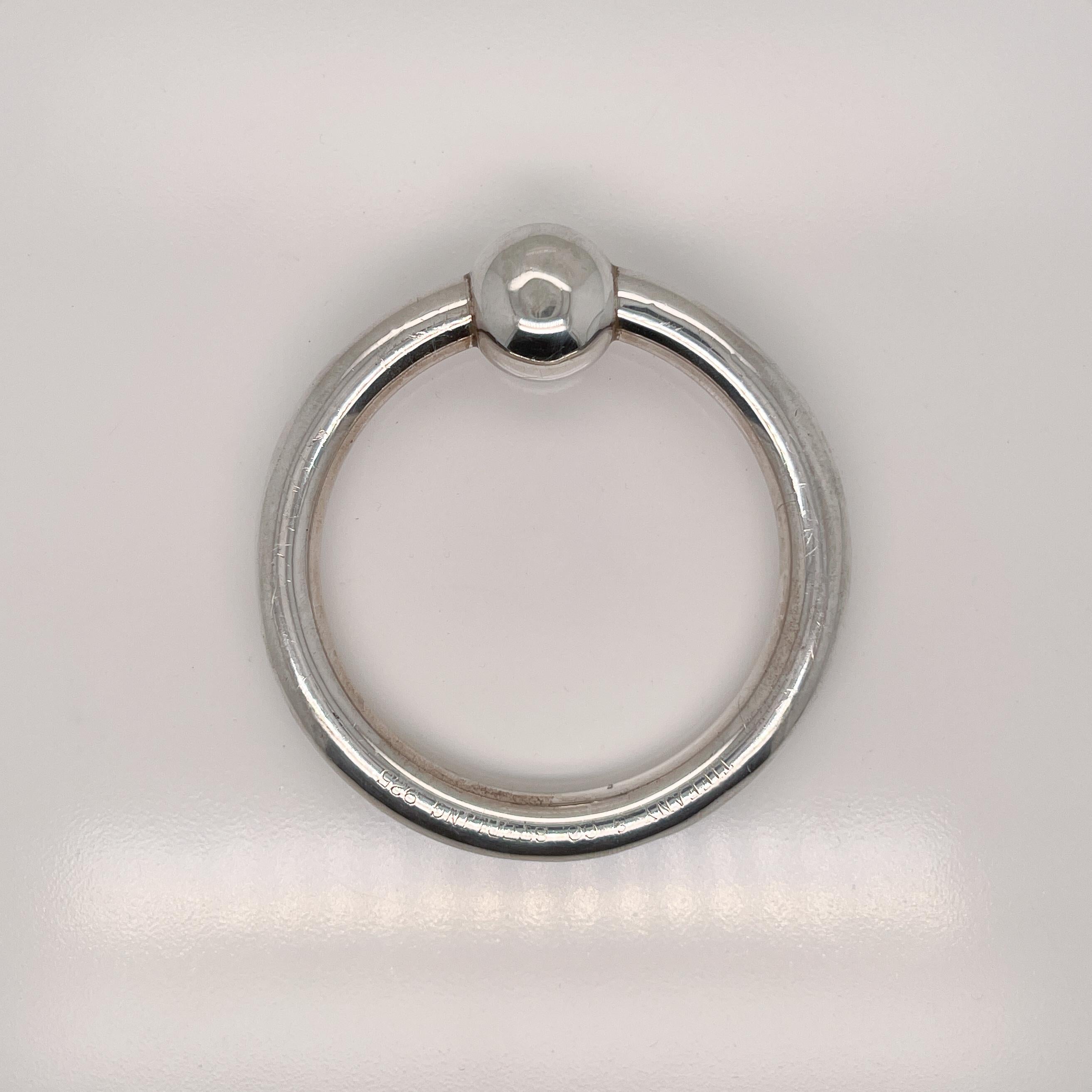 A fine sterling silver baby teething ring.

By Tiffany & Co.

With an internal rattle.

Simply a great piece from Tiffany & Co!

Date:
Mid-20th Century

Overall Condition:
It is in overall fair, as-pictured, used estate condition.

Condition