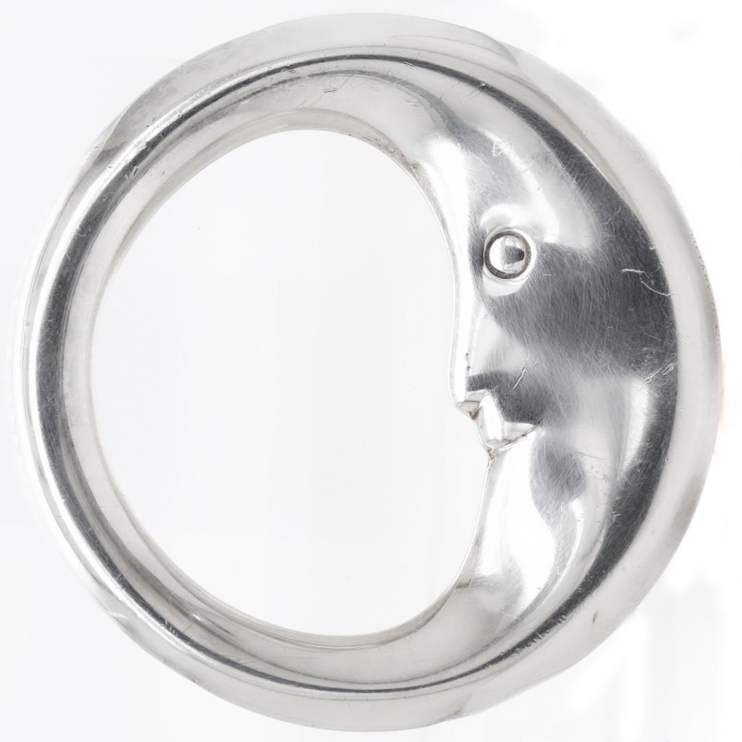 A fine sterling silver baby teething ring.

By Tiffany & Co.

In the form of a crescent moon with a face.

The ring rattles when shaken.

Simply a wonderful design by Tiffany!

Date:
20th Century

Overall Condition:
It is in overall good,