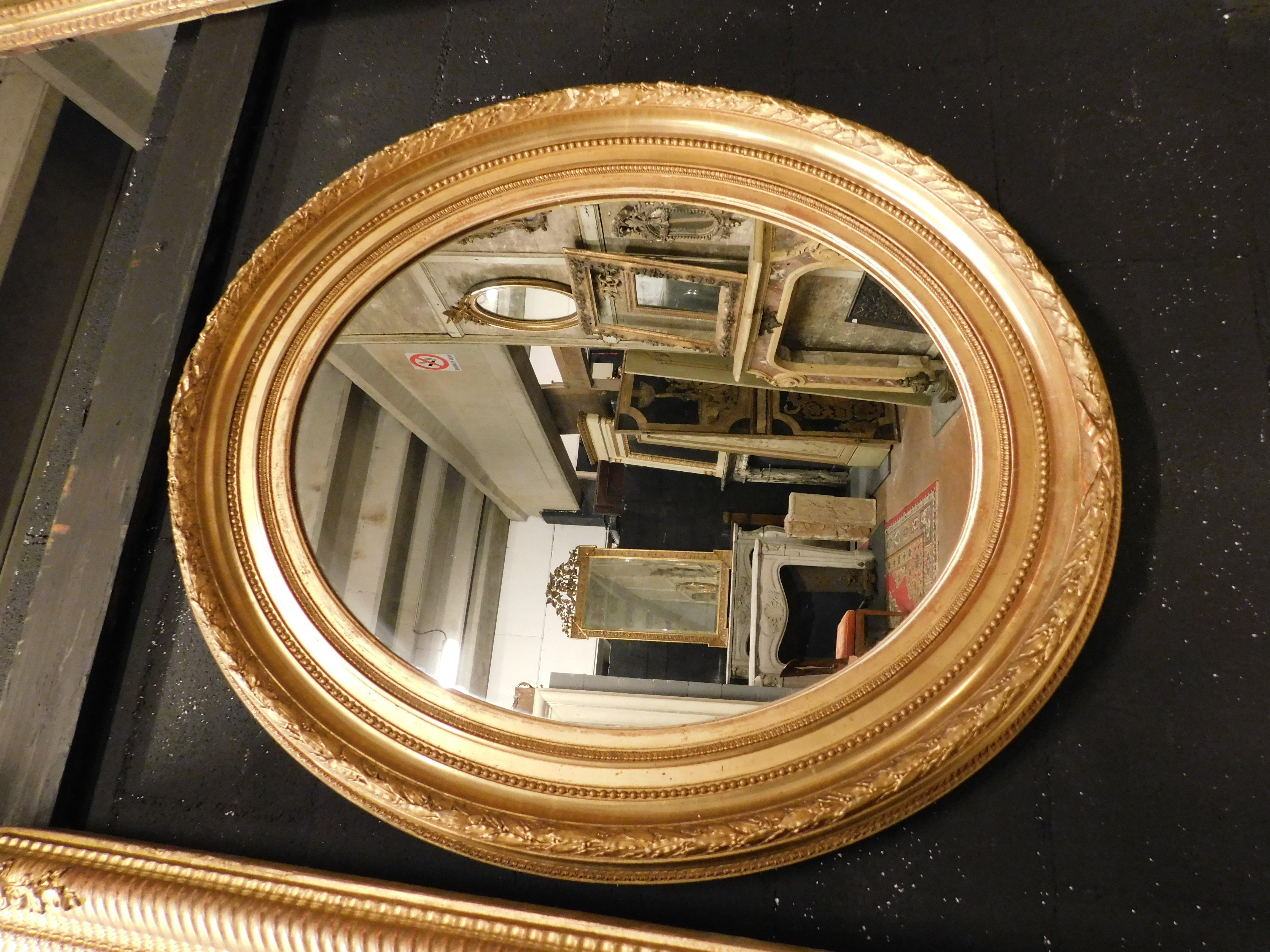 Ancient oval mirror, with carved and gilded wooden frame, double frame, built in the 19th century in Italy, ideal for placing on the wall or on top of a piece of furniture, or as a contrast in a modern but luxurious environment, measuring w 70 x H