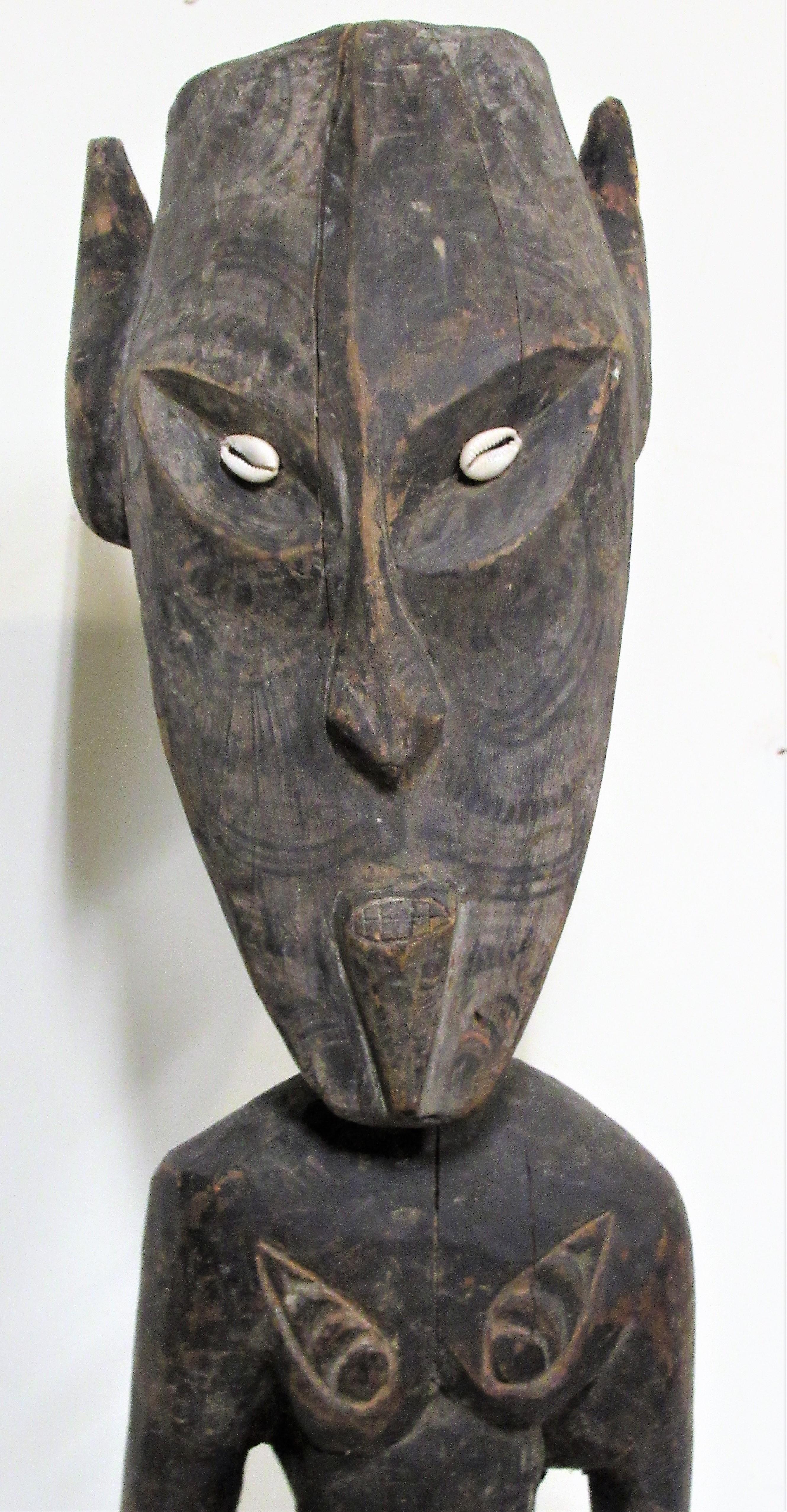 Figure ancestrale masculine debout de Papouasie-Nouvelle-Guinée, sculptée à la main dans un seul morceau de bois. Surface pigmentée ancienne magnifiquement vieillie avec des traits de visage finement décorés et des yeux en coquillage. Une présence