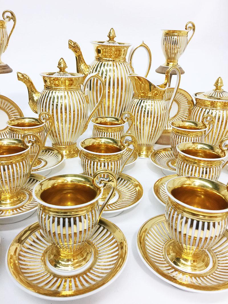 Old Paris porcelain coffee and tea set, 40 pieces, 19th century

A white ribbed porcelain with gold paint service with a very large coffee pot, teapot, lidded sugar pot, a creamer and 18 cups and saucers

Coffeepot measures 29 high, 20 cm wide and