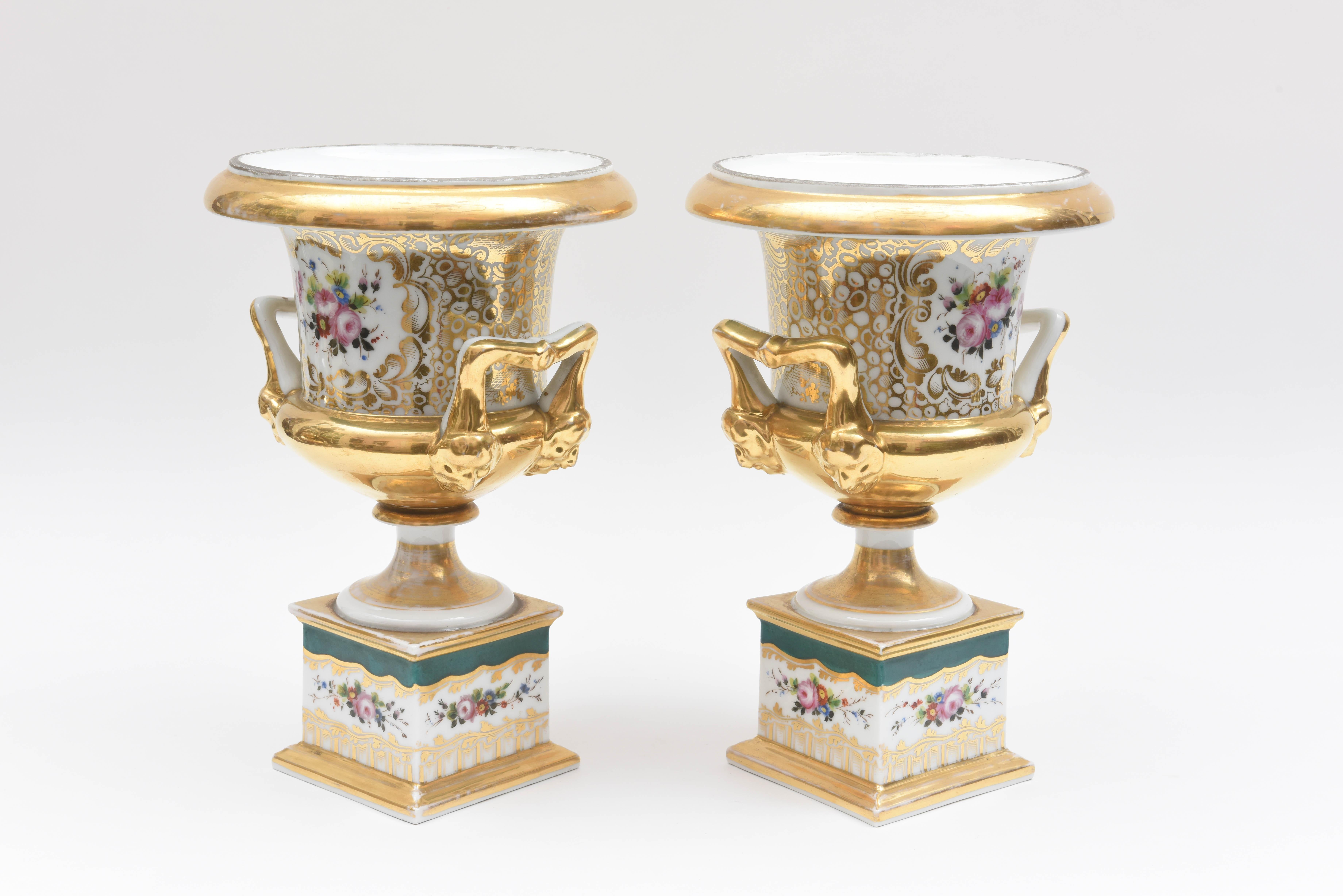 A classic and elegant pair of vases from one of the storied Old Paris porcelain factories. Crisp white porcelain ground with full hand-painted flower surrounds. Accented with a rich green color and retaining much of its original 24-karat gold.