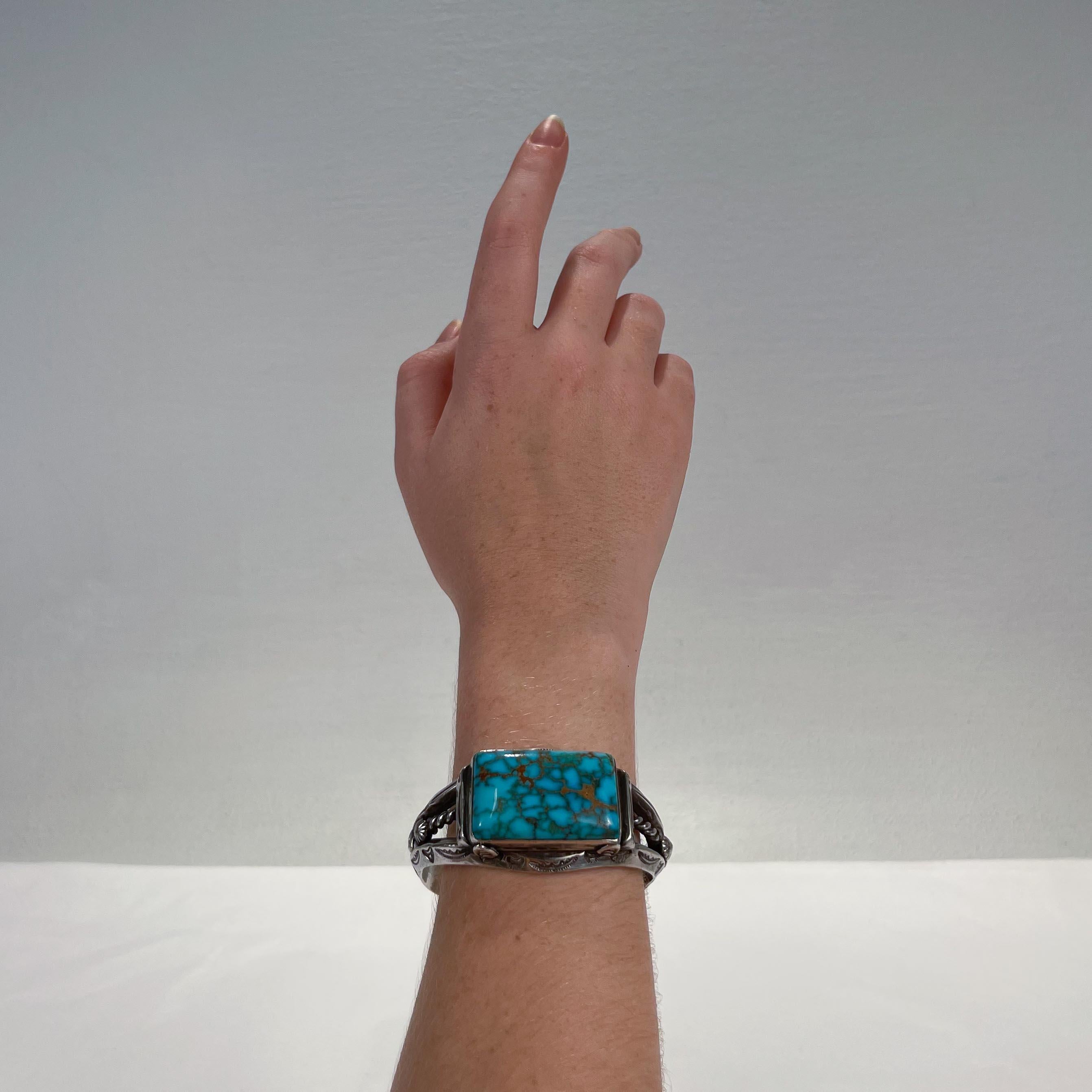 A fine Navajo turquoise and silver cuff bracelet.

Bezel-set to the top with a large cabochon matrix turquoise. 

The sides & bridge are struck with with Native American pictographs/typical symbols or devices.

A substantial bracelet that feels