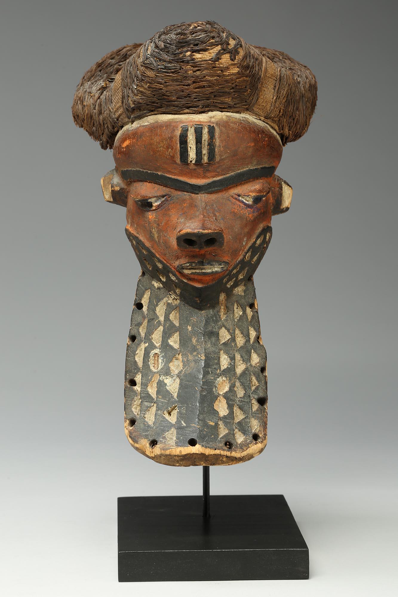 Old Pende giwoyo mask with red pigments, black and white beard with carved triangles and woven black raffia hair cap
The mask is 13 1/4 inches high, on custom wood base total height 14 inches.


