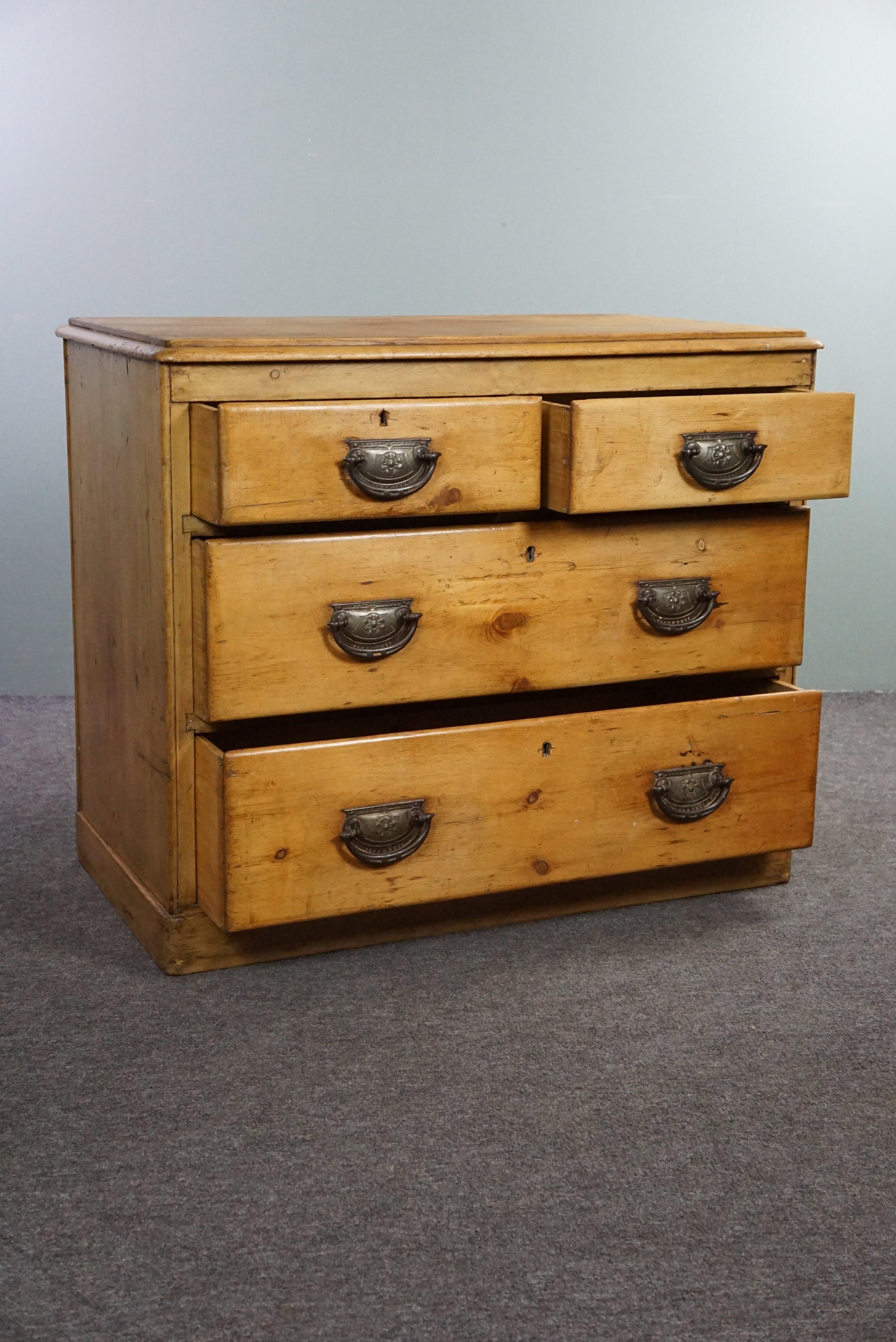 Offered is this beautiful light old pine chest of drawers.

This Victorian English chest of drawers, from the 19th century, has a beautiful warm honey-like color. The four well-functioning drawers have beautiful handles with many ornate details. The