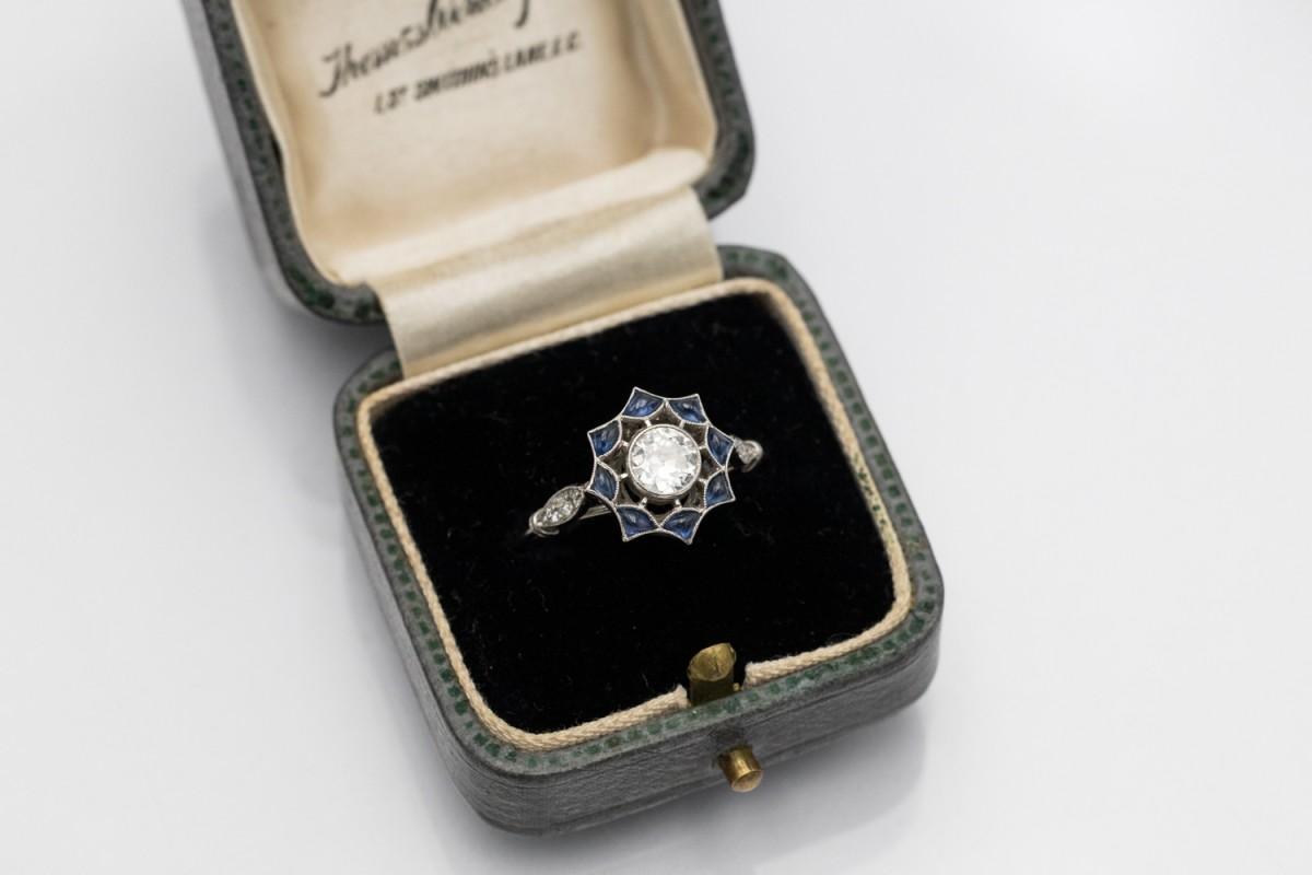 Exceptionnelle bague en platine, ornée au centre d'un diamant de taille ancienne brillant pesant 0,40 ct (couleur J, pureté VS2). Entourée finement de saphirs, elle crée la forme d'une étoile, d'un soleil. Masse totale des saphirs environ 0,40