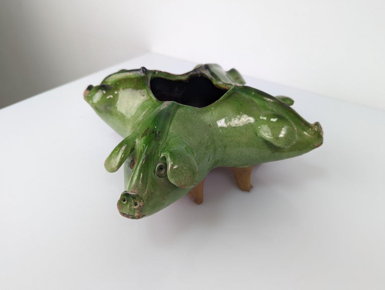 Fantastic work glazed in green formed by four pigs and their eight front legs with a central office as a center. A super original piece with a lot of charm.