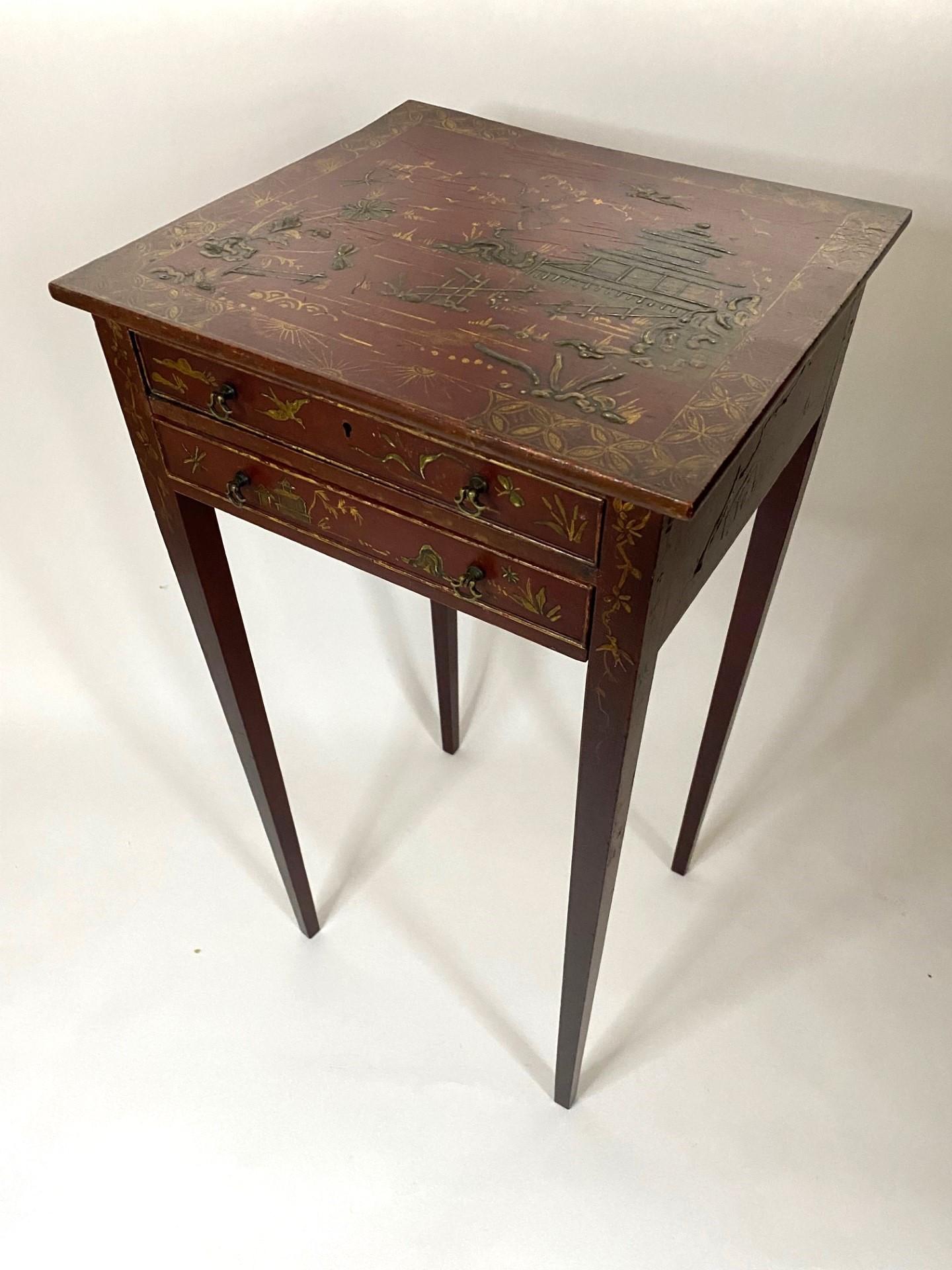 Interesting and attractive 19th century small two drawer red lacquered table with hand painted chinoiserie decoration on top and all sides on square tapered legs.