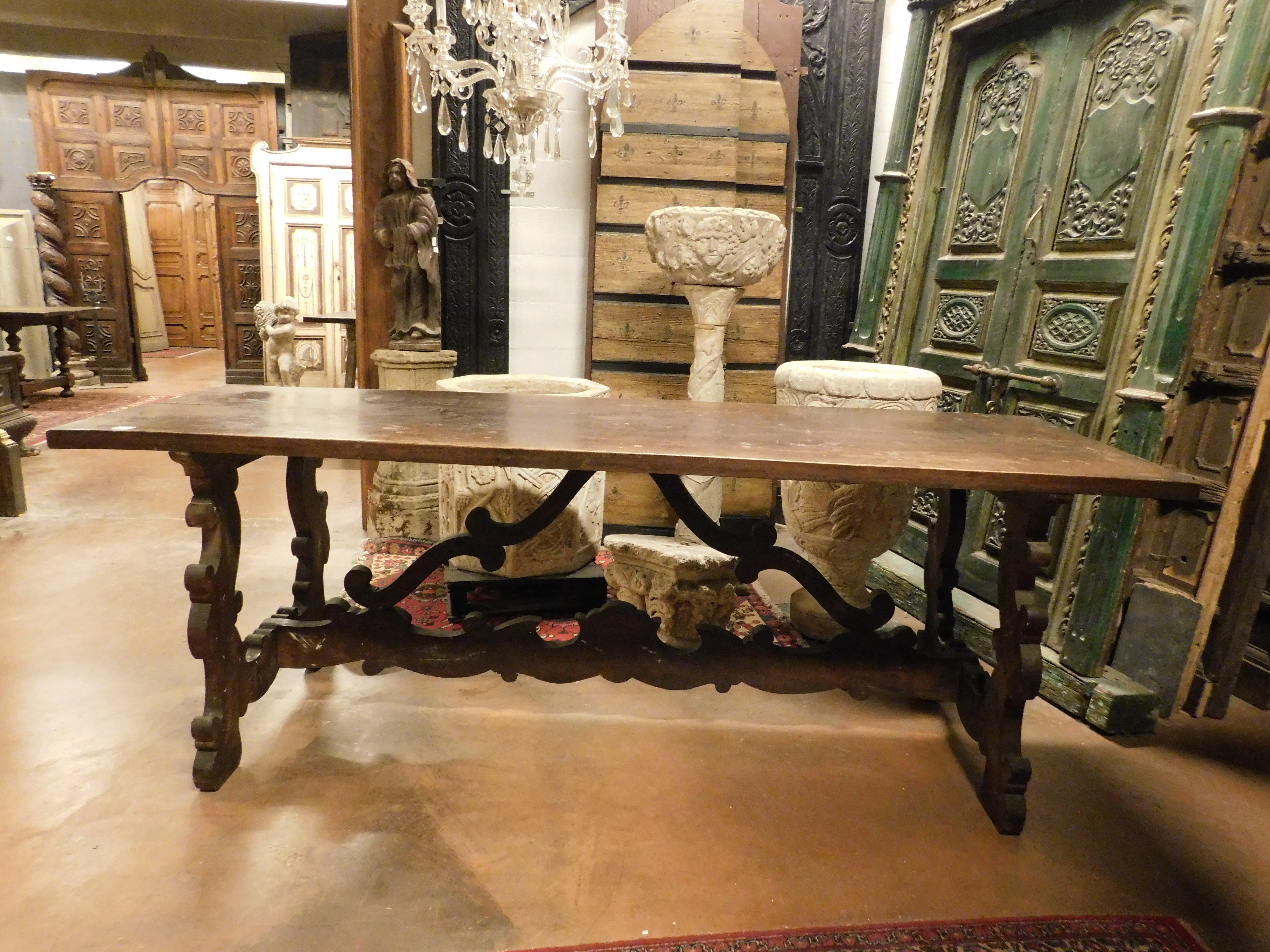 Grande table de réfectoire ancienne, en noyer, avec un double plateau très épais et des pieds ondulés richement sculptés, fabriquée à la main à la fin des années 1800, en Italie.
Idéale à la fois comme table d'appoint et comme éventuelle table de