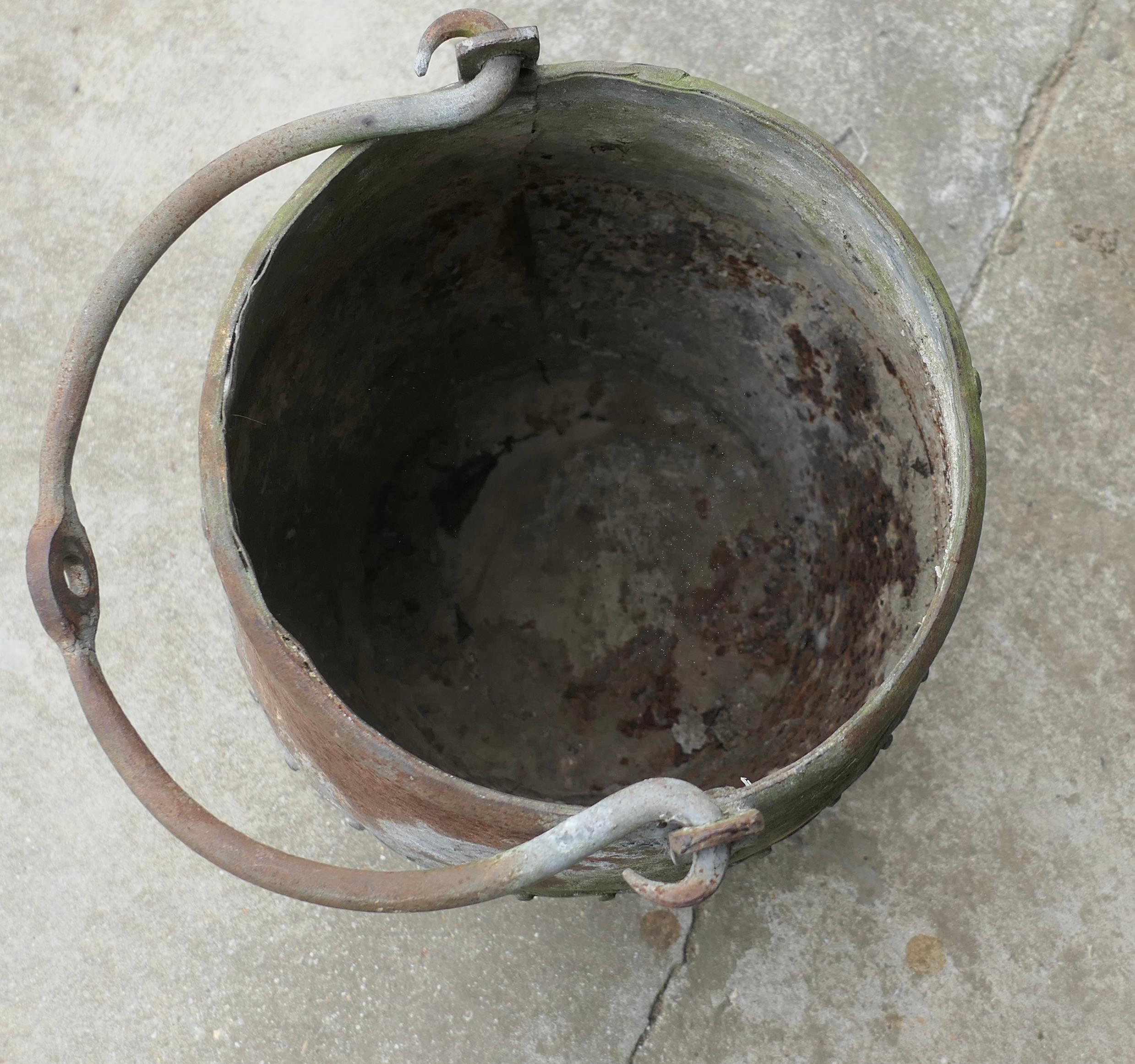 Ancien seau de puits riveté 

Il s'agit d'un rare seau de forme traditionnelle utilisé pour les puits profonds. Cette charmante pièce a une construction rivetée et une poignée pivotante. 
Le seau est en bon état, il n'est probablement plus étanche,