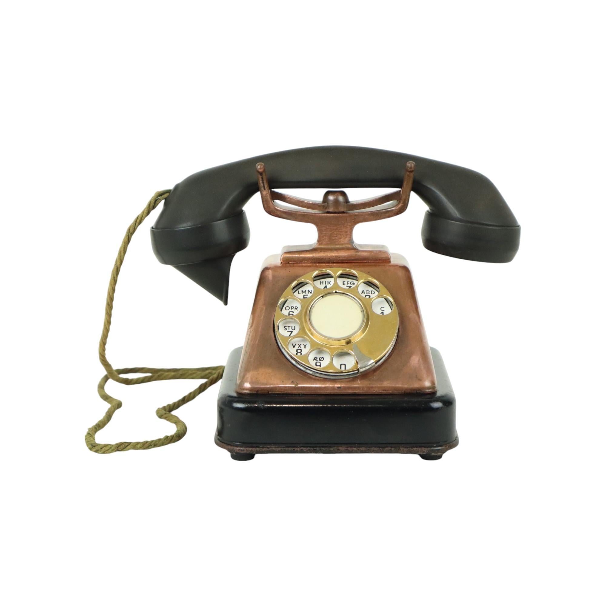 Raro vecchio telefono rotante in acciaio laccato nero, acciaio ramato, ottone e ricevitore in bachelite, probabilmente di KTAS, modello sconosciuto ma nello stile del D30, Danimarca, anni 1930-40 circa.

Questo bellissimo telefono è estremamente