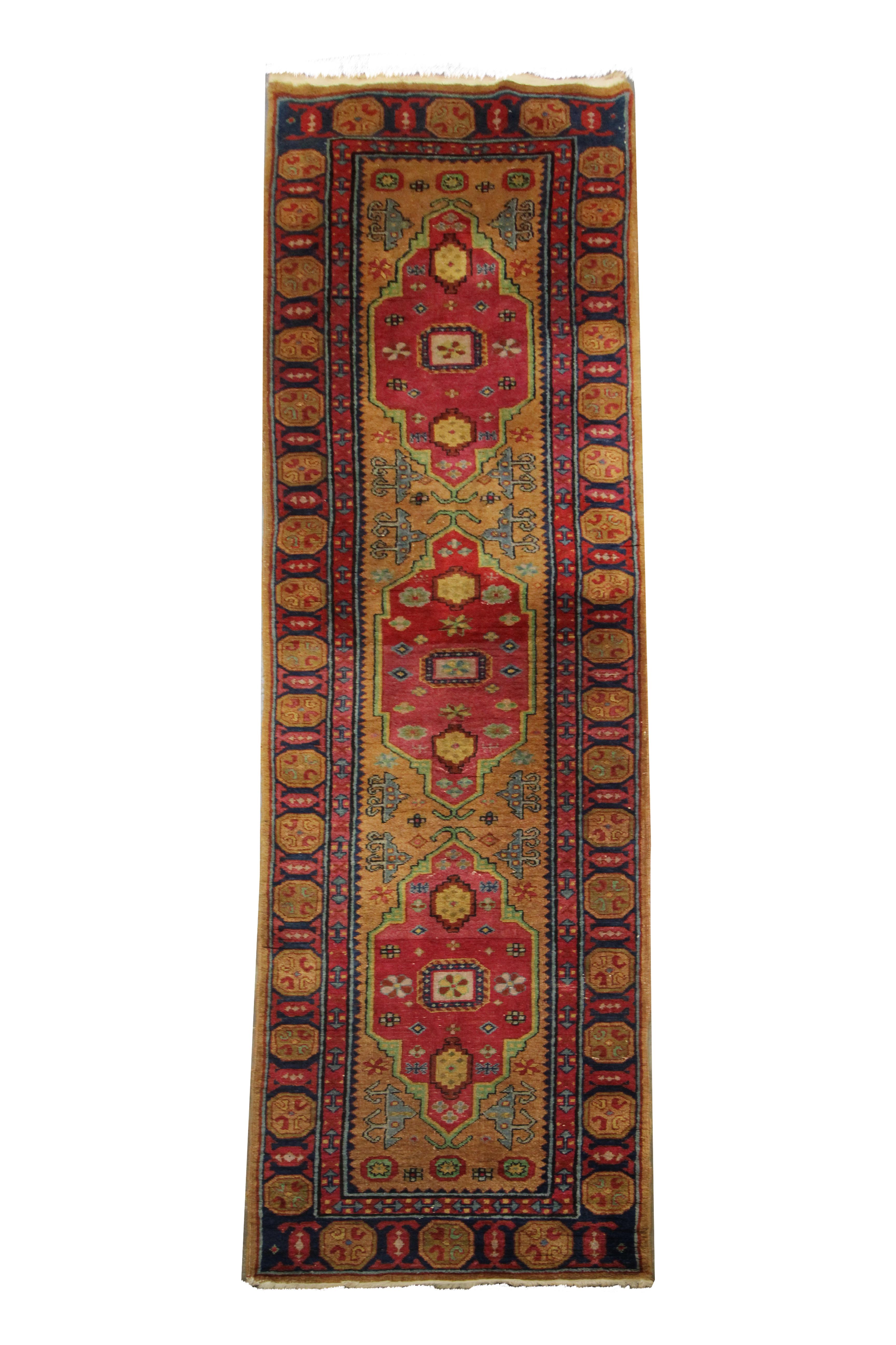 This bold wool rug is an antique Armenian Runner rug woven by hand in the early 20th century, circa 1910. The central design has been woven on a mustard-yellow background with red accents that make up the bold trio of medallions that run
