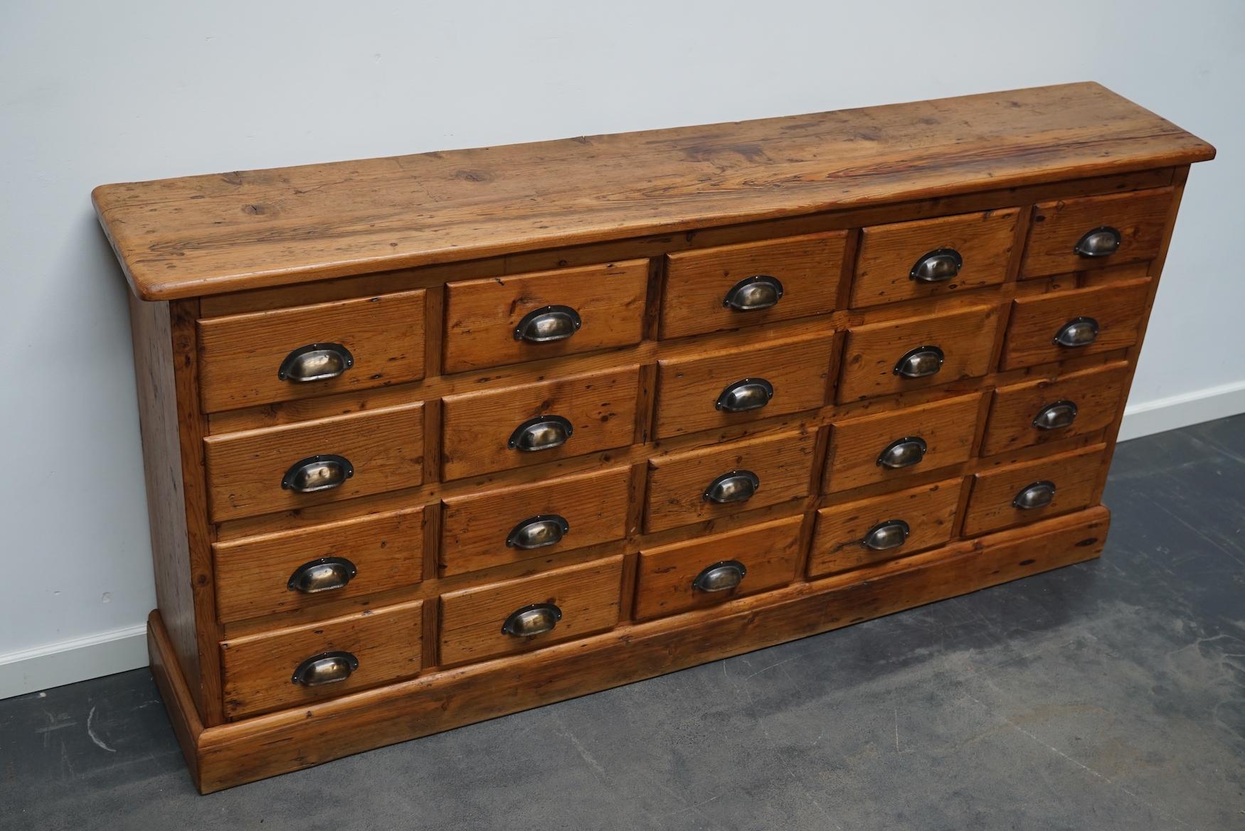 This pine apothecary cabinet with brass hardware was made in the early 20th century in France. It is very well made and it remains in a good condition. The interior dimensions of the drawers are: D W H 22 x 23 x 10 cm.