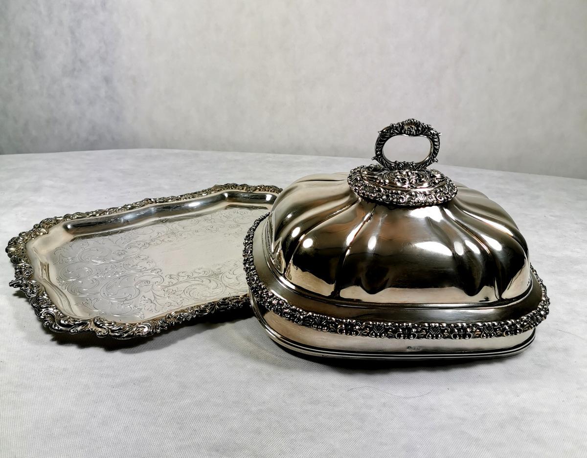 The dish cover rests on a rectangular shaped tray, as was in use in the early '800, the borders are embossed in silver leaf, moreover, the technique of covering the underlying copper with thin silver profiles is applied to the edges, a technique