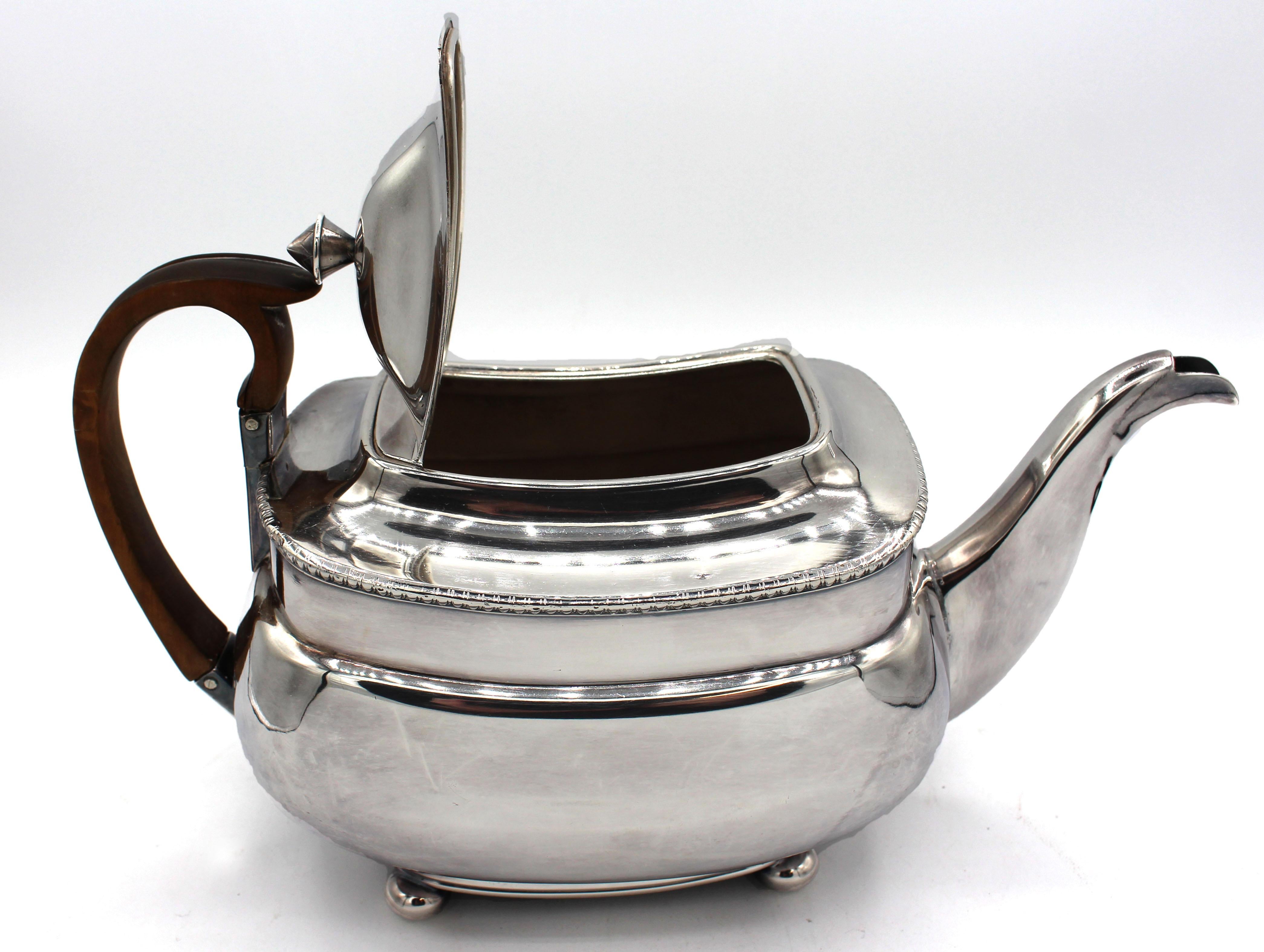 Old Sheffield plate tea pot with pearwood handle, circa 1820, English. Classical period. Egg & dart border, ball feet. One tiny dimple on top.
11.25