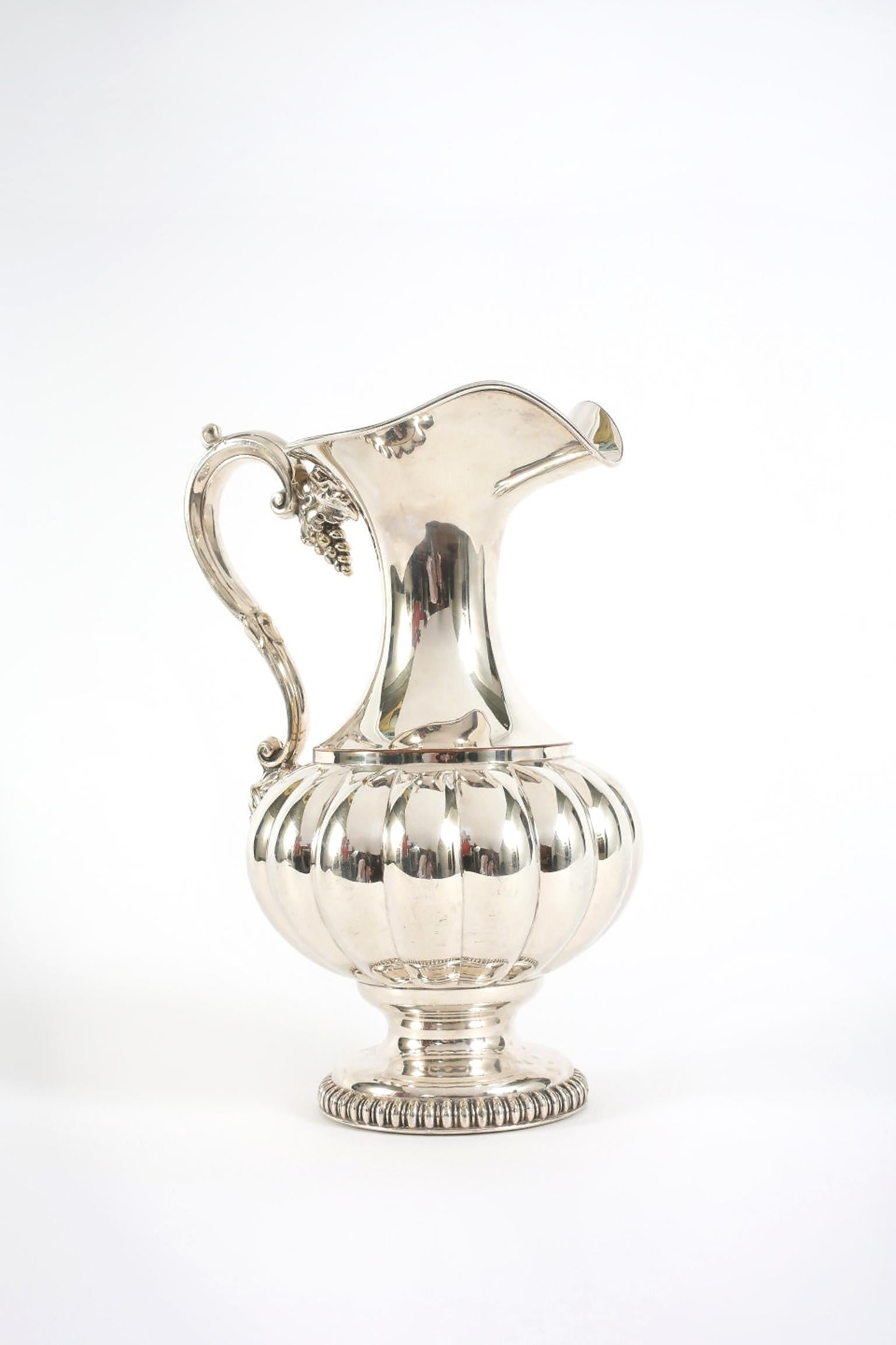 Old Sheffield silver plated water pitcher / wine pourer with exterior design details. The pitcher is in great antique condition with appropriate wear consistent with age / use. The pitcher Stand about 11 inches high x 8 inches diameter.