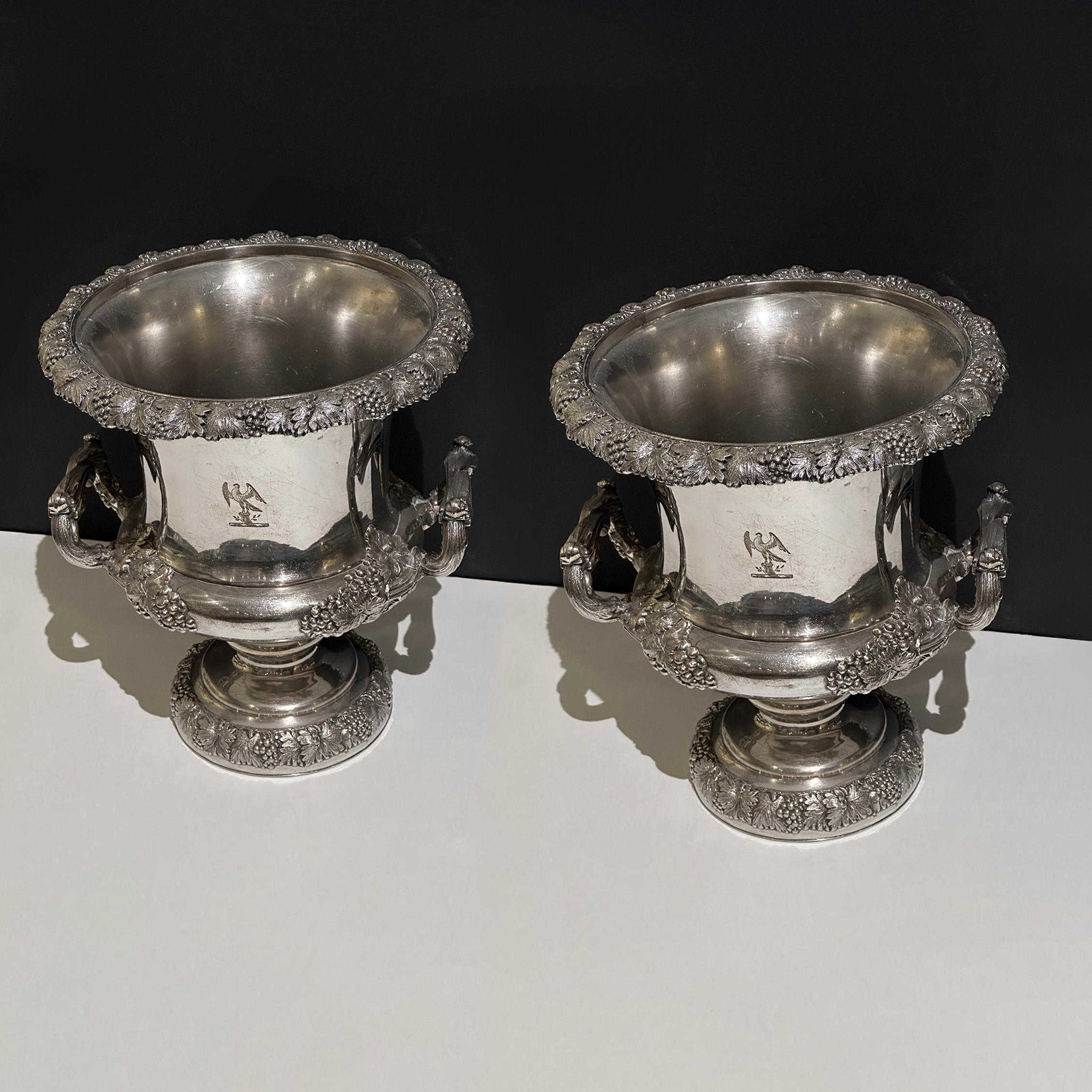 Un'eccezionale coppia di refrigeratori per vino in argento Old Sheffield del XIX secolo di Mappin Brothers, elegantemente realizzati nel classico stile Medicis. I loro corpi raffinati e sobri sono splendidamente valorizzati da bordi finemente