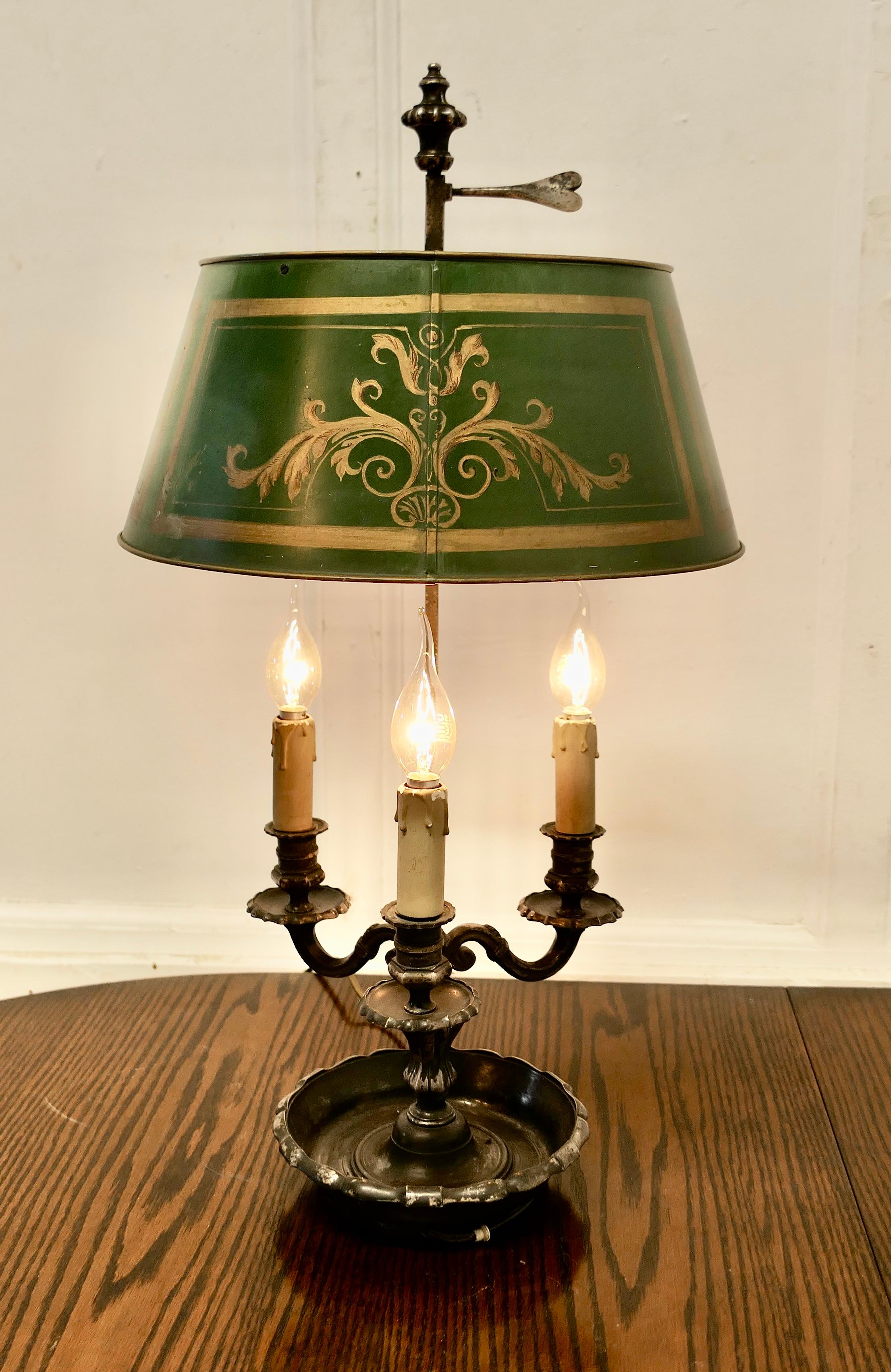Lampe de bureau triple bouillotte française en métal argenté ancien

Une belle pièce, une ancienne lampe à triple applique en métal argenté, accompagnée de son abat-jour Toleware d'origine décoré de motifs de feuilles classiques. 
La lampe